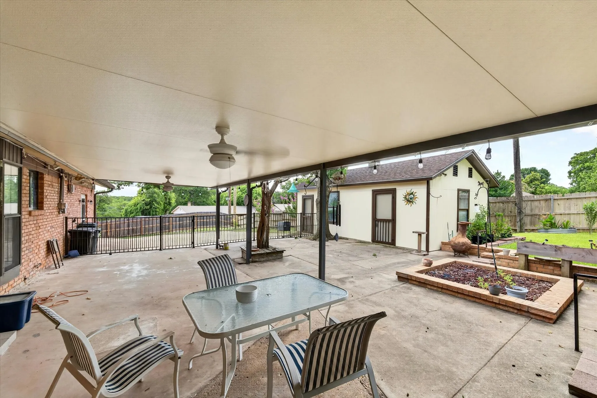 Expansive covered patio featuring two ceiling fans and concrete flooring