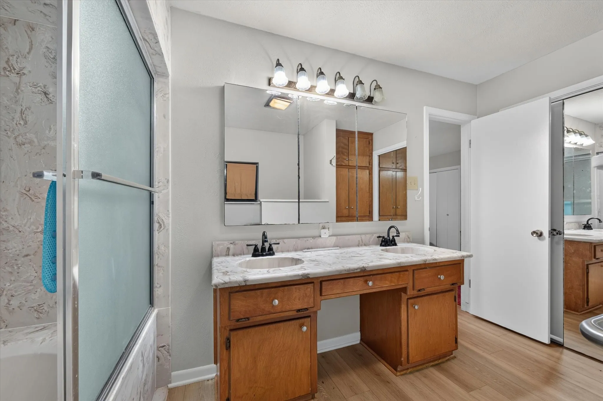 Double vanity with integrated sinks, granite-look countertop, and wood-finish cabinetry