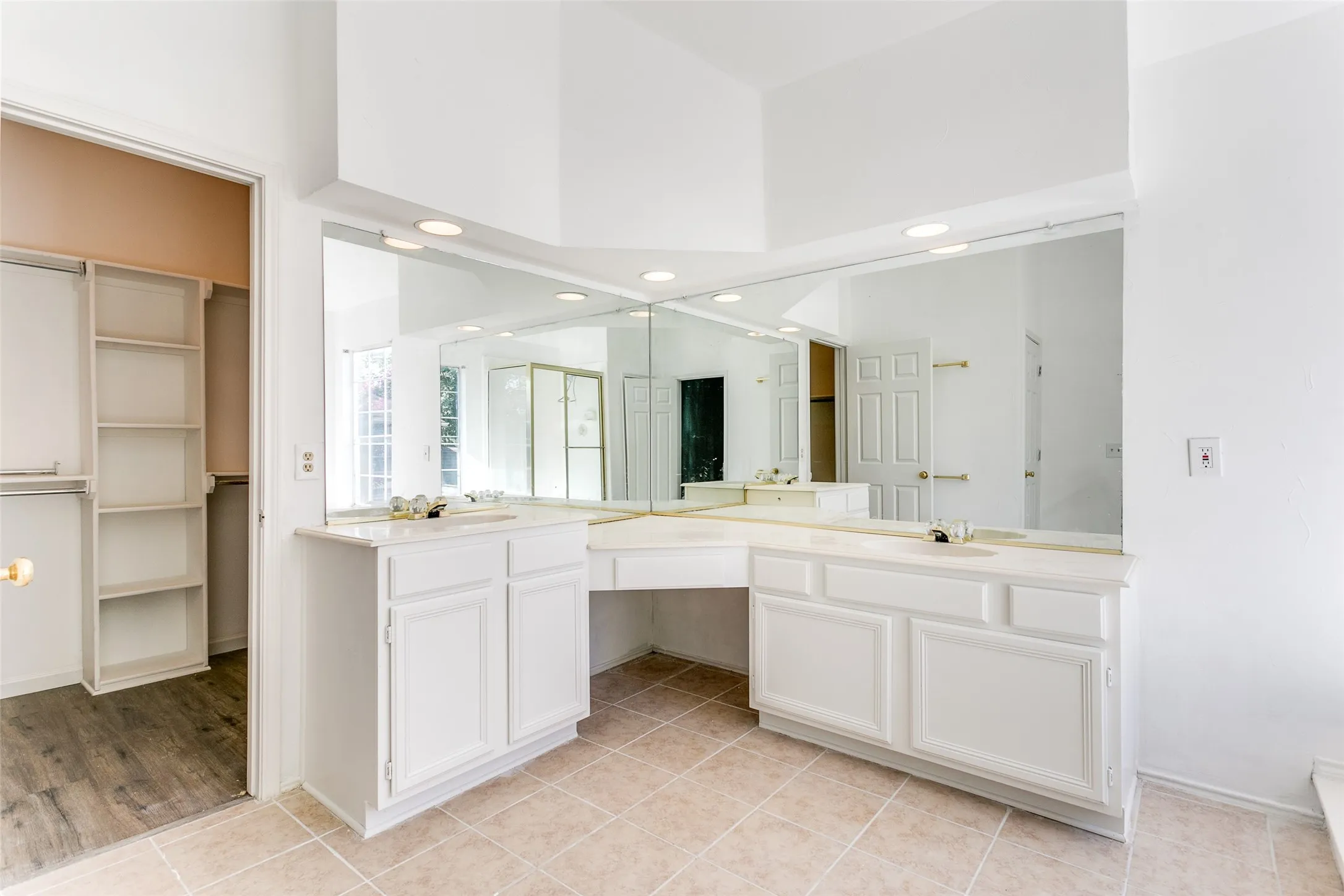 Bathroom with tile patterned flooring, dual bowl vanity, and a high ceiling