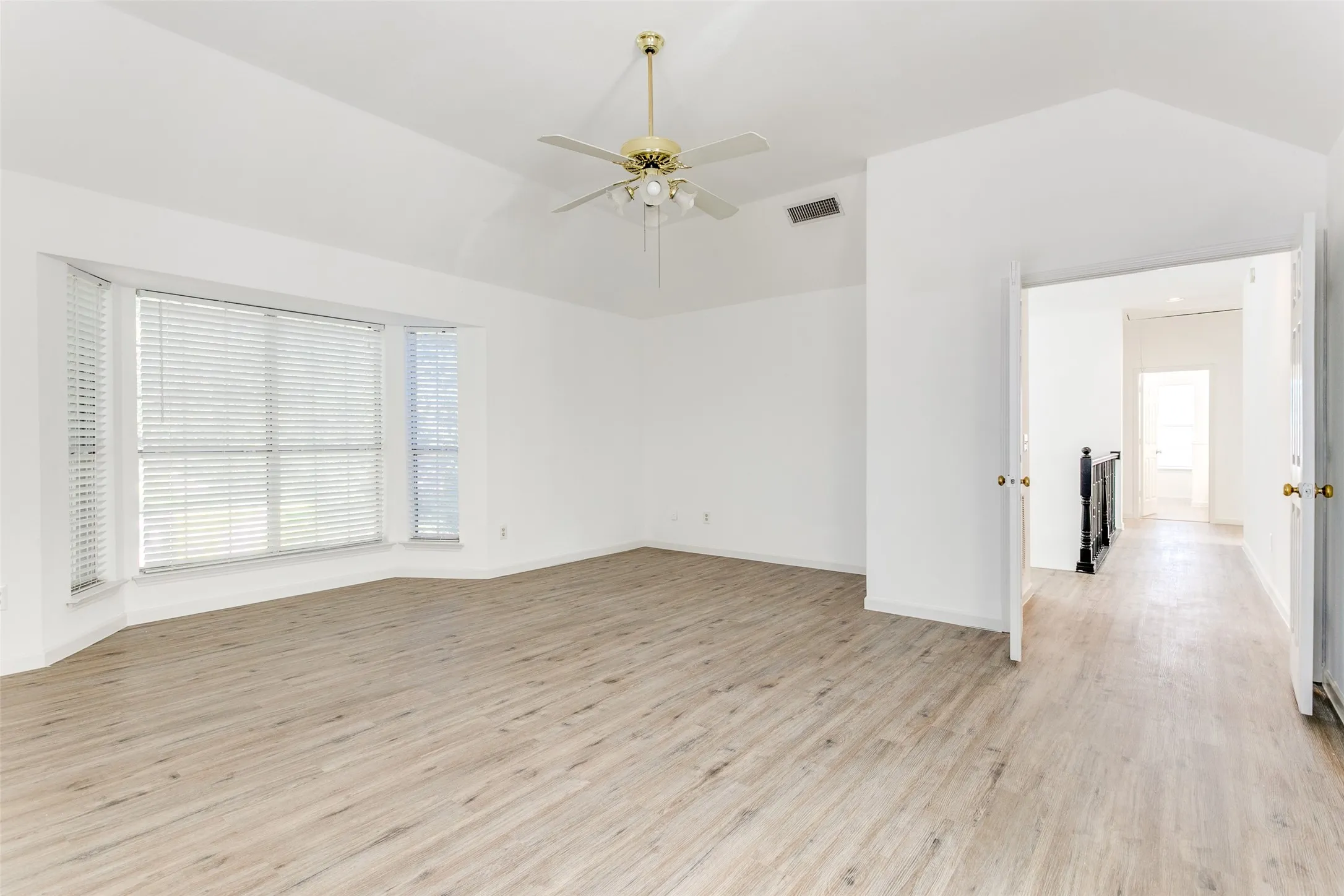 Spare room with vaulted ceiling, light hardwood / wood-style flooring, and ceiling fan