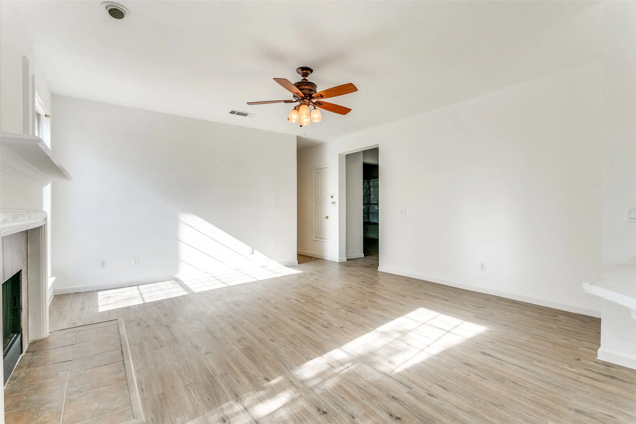 Unfurnished living room featuring light hardwood / wood-style flooring and ceiling fan