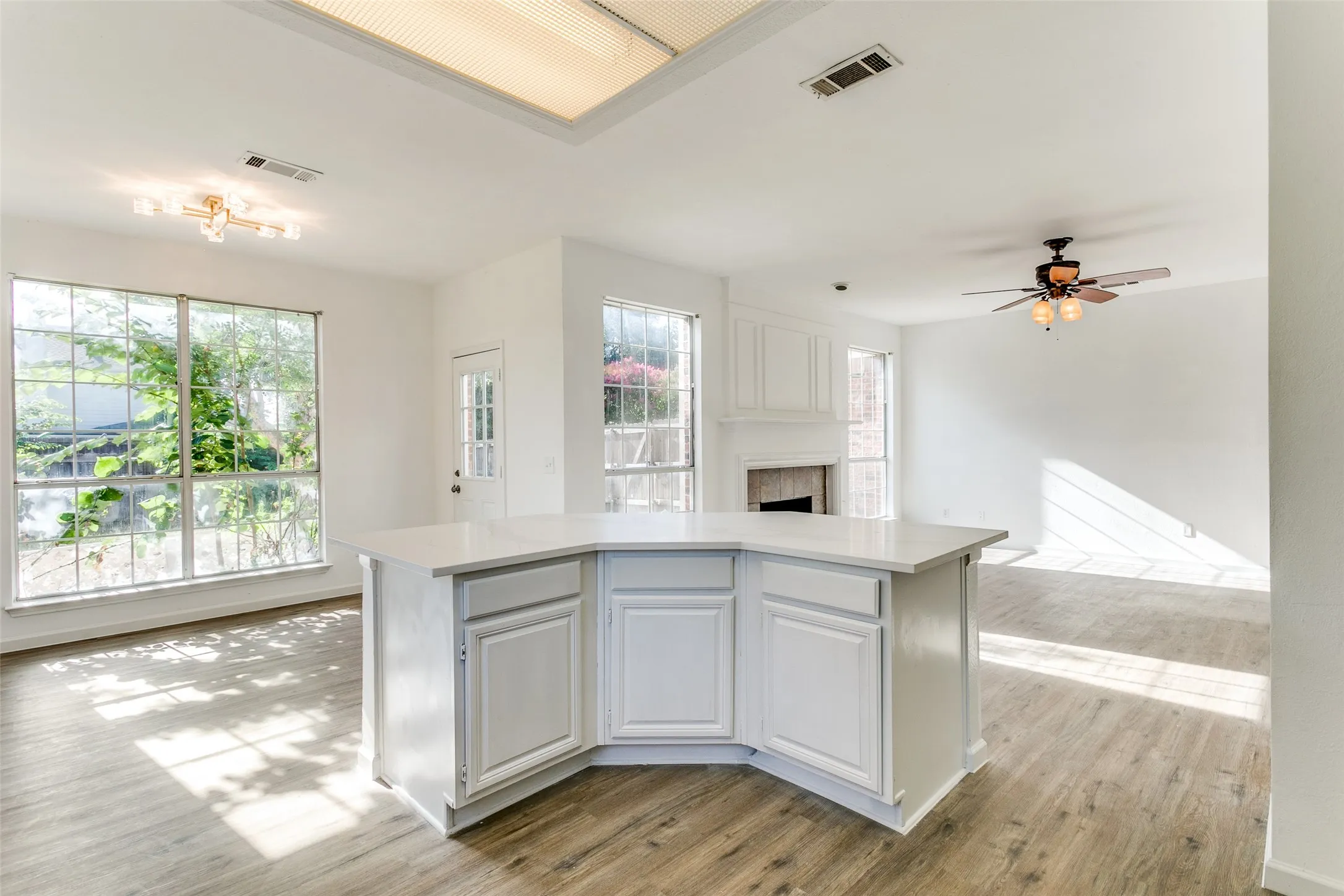 Kitchen featuring white cabinets, a wealth of natural light, light wood-type flooring, and ceiling fan