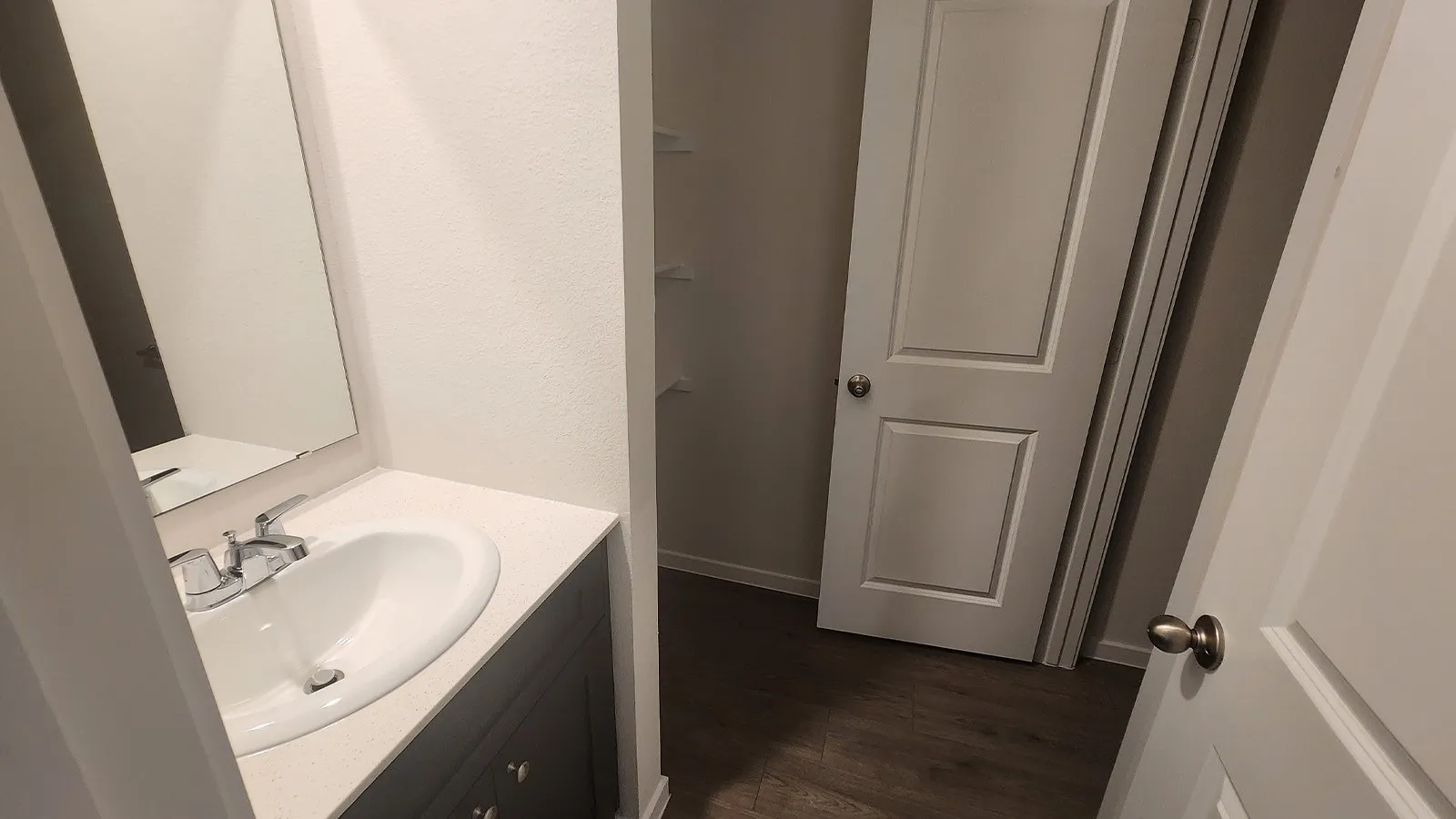 Vanity with an integrated white sink, chrome faucet, and a light-colored countertop