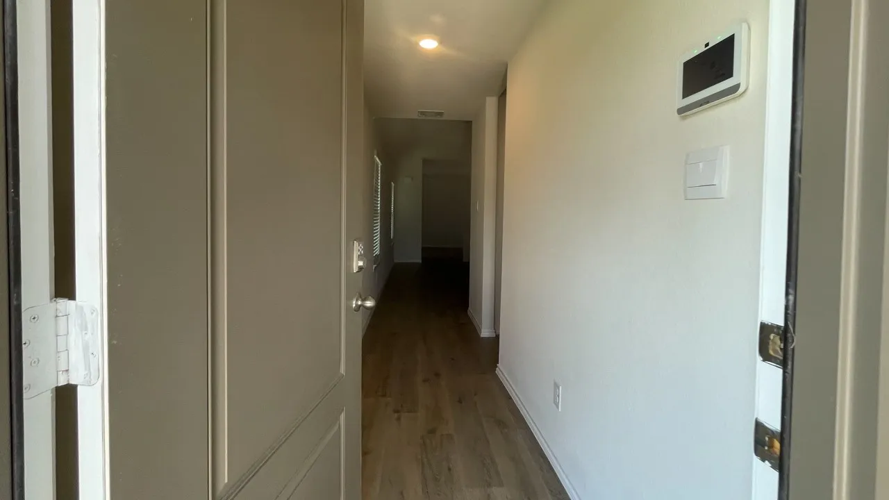 Entryway featuring wood-finish flooring extending through the hall, recessed lighting, and a neutral wall palette