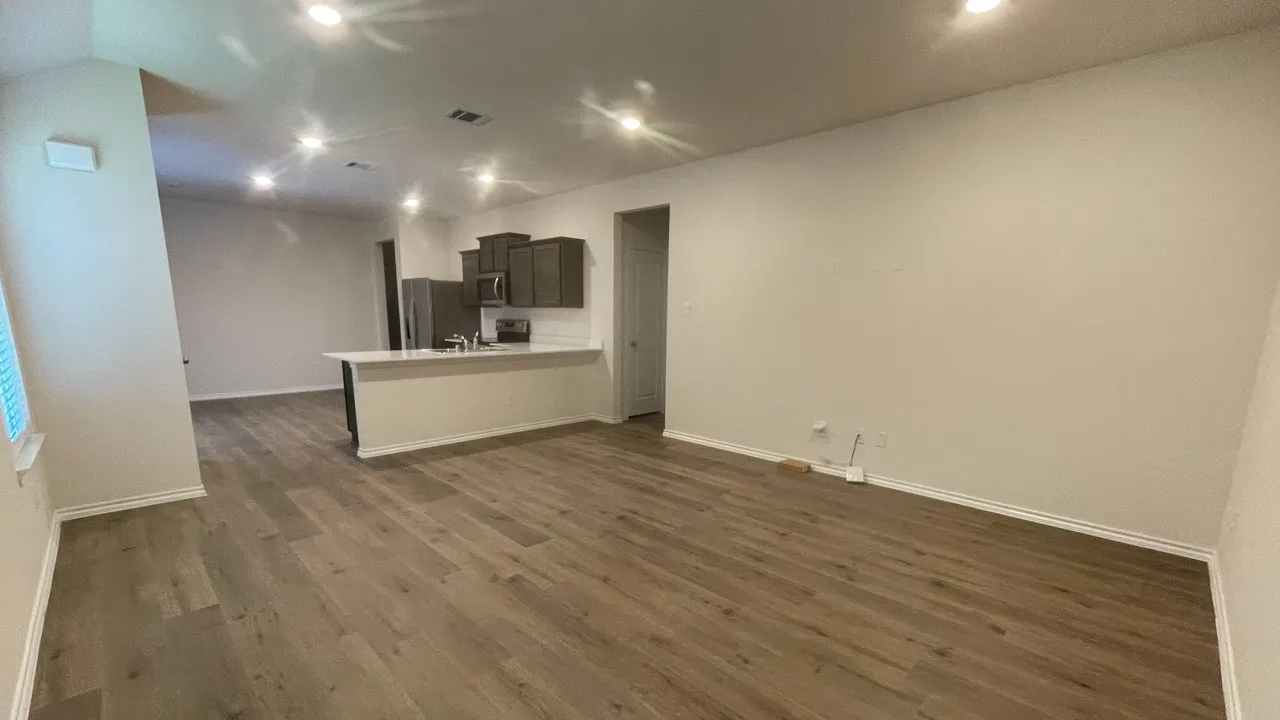 Open-concept living space featuring wood-finish flooring, recessed lighting, and a neutral color palette