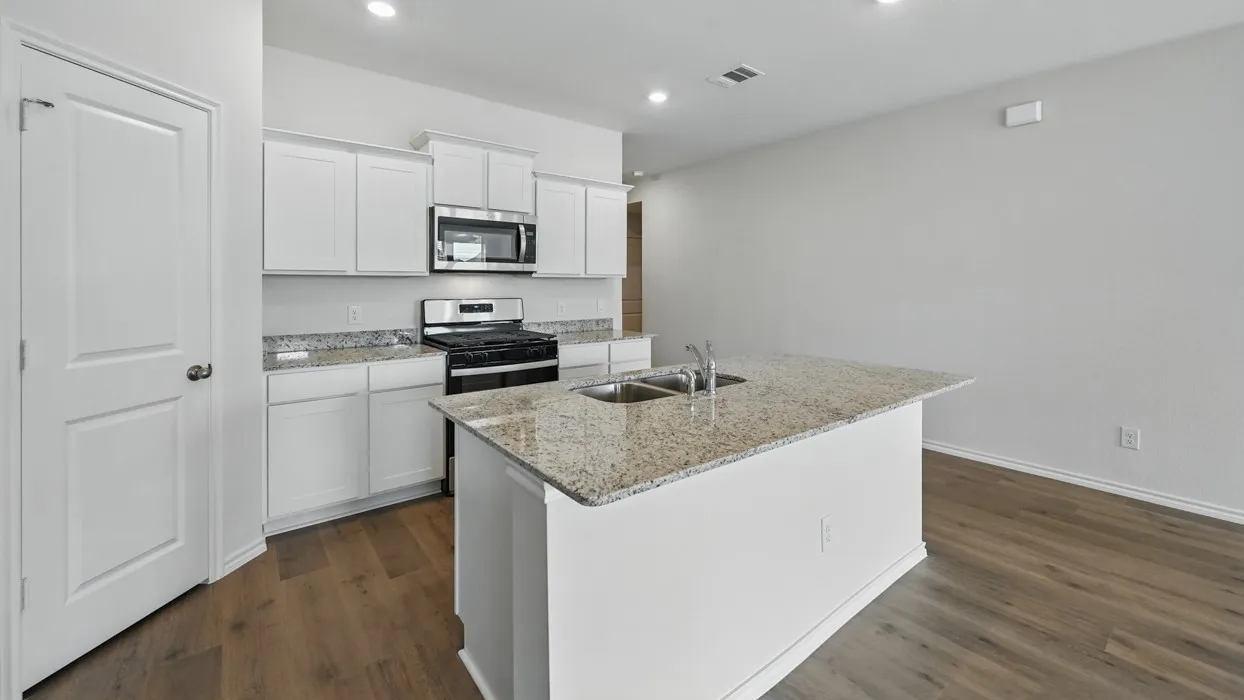 Kitchen featuring a central island with dual sinks, white cabinetry, granite countertops, and stainless steel appliances