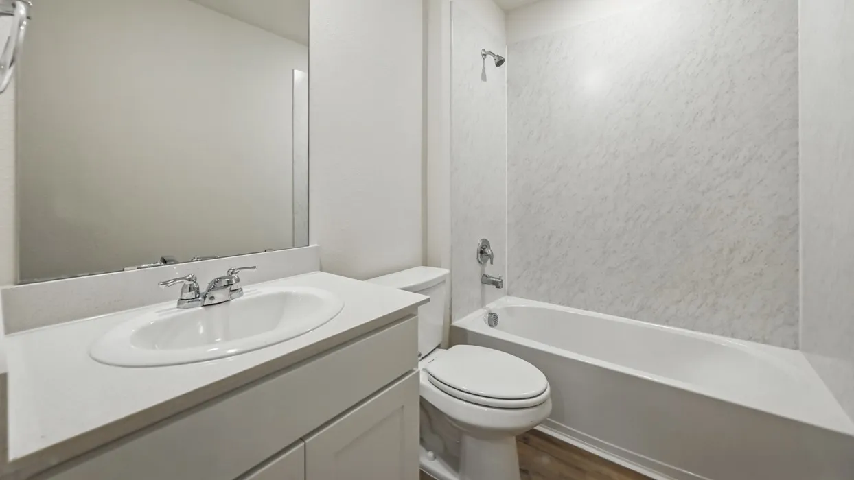 Bathroom featuring a white vanity with an undermount sink, chrome faucet, and integrated backsplash