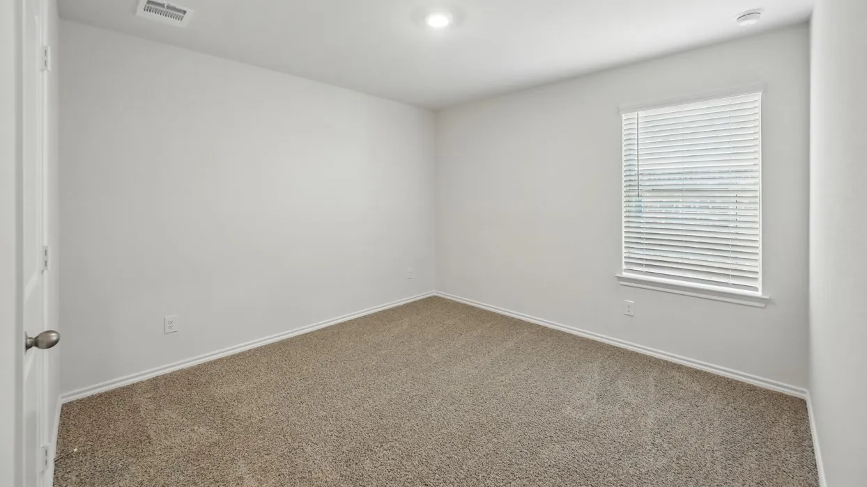Carpeted interior room featuring a single window with blinds, recessed lighting, and white baseboards