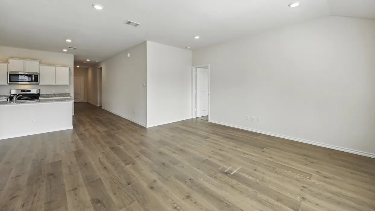 Open-concept living area featuring wood-finish flooring, recessed lighting, and a neutral color palette