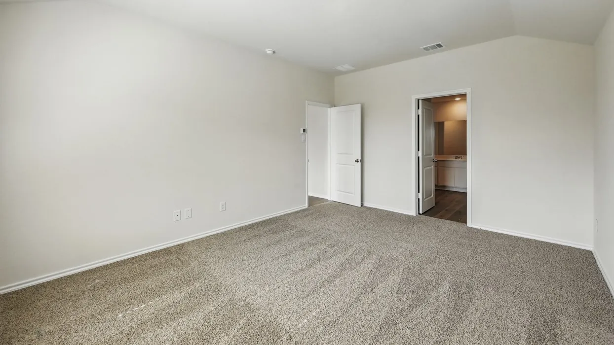 Spacious room with neutral-toned carpeting, light-colored walls, and a vaulted ceiling