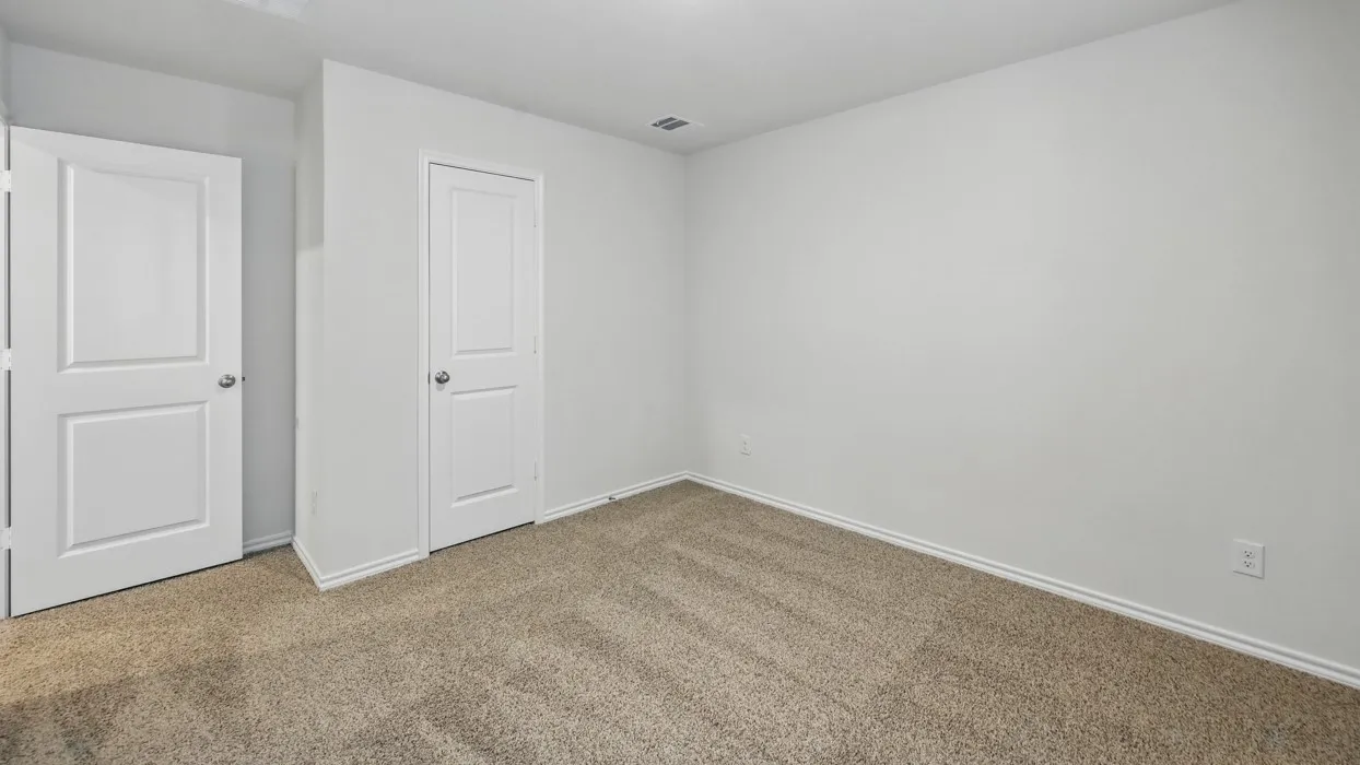 Neutral wall color with two-panel interior doors, light-toned carpeting, and white baseboards