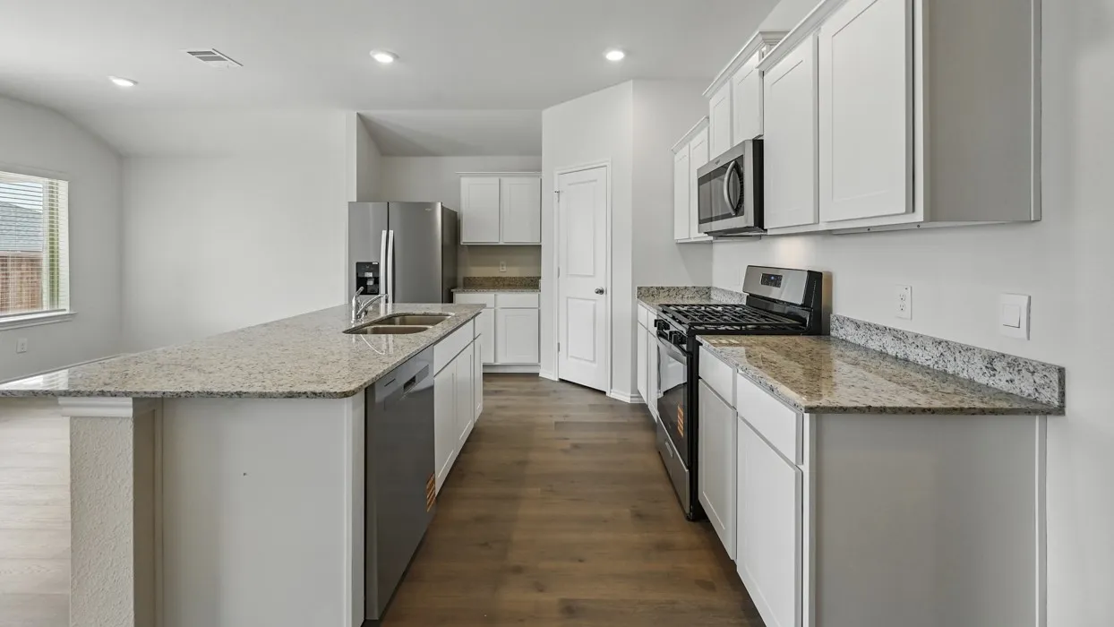 Kitchen featuring wood-finish flooring, white cabinetry, and light-toned granite countertops