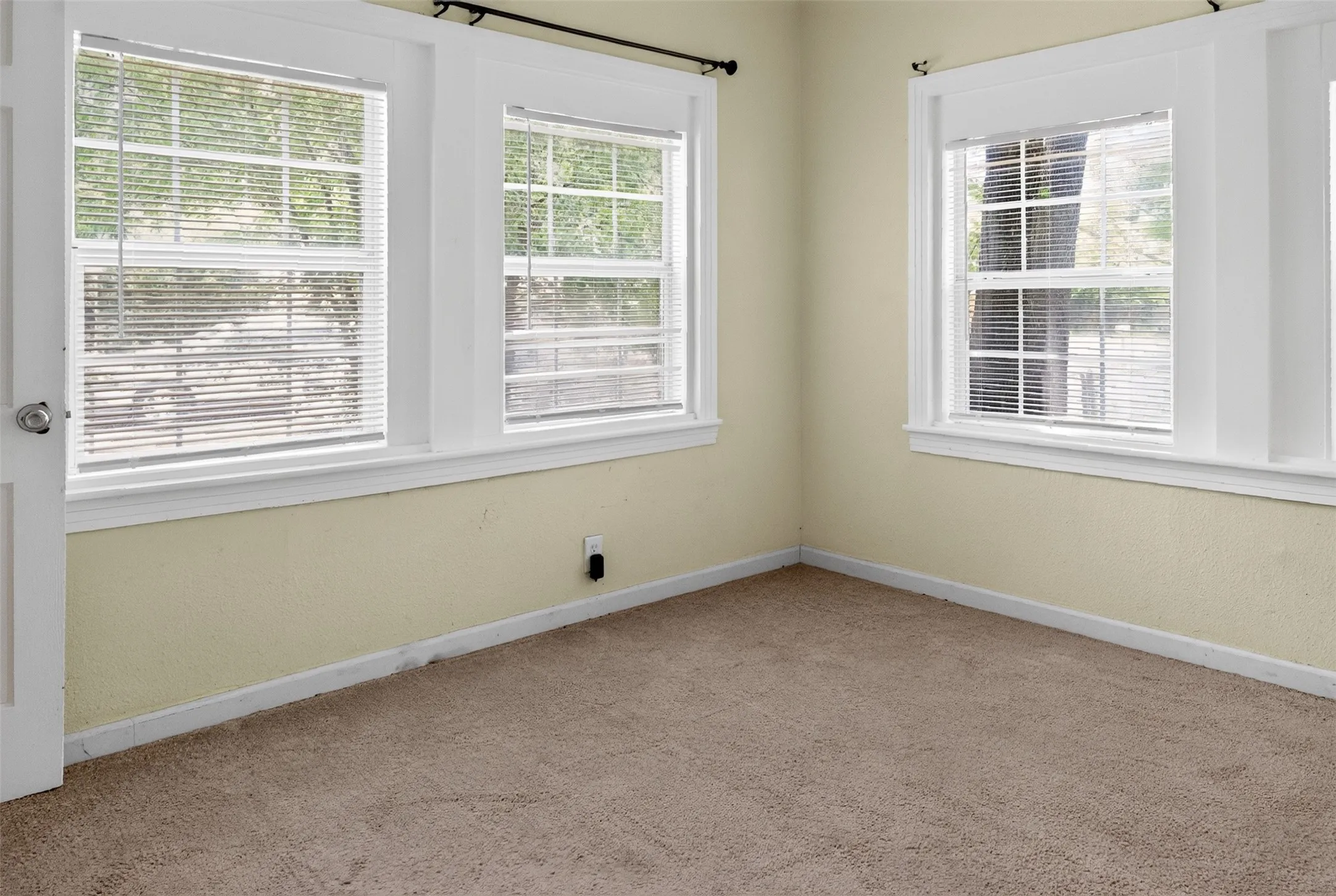 Carpeted interior room with multiple windows