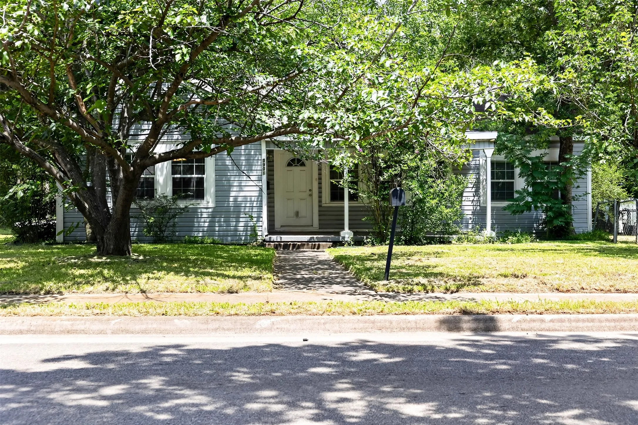 Light blue siding exterior with white trim windows and a white front door