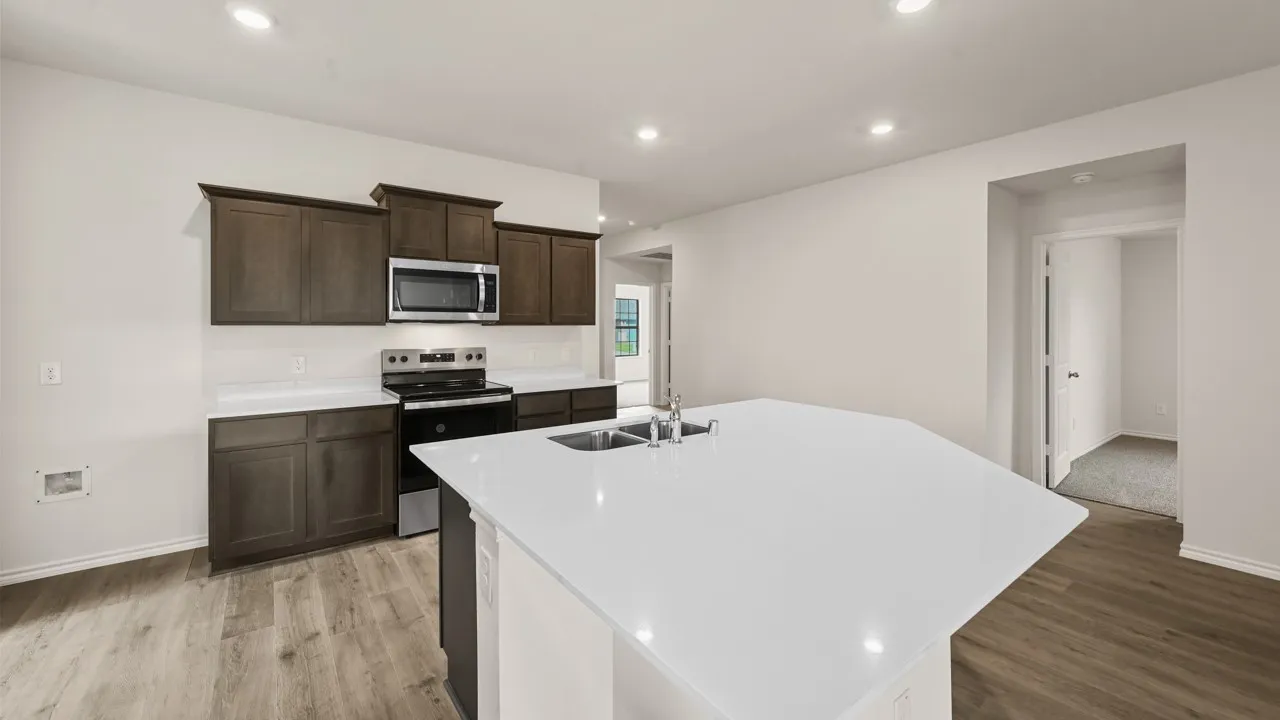Contemporary kitchen featuring an expansive island with an undermount sink and a stainless steel faucet