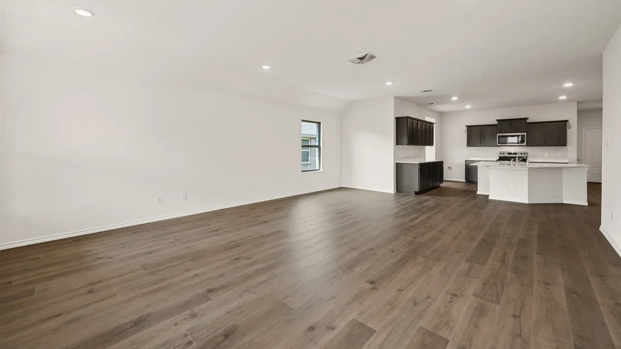 Open-concept living area with wood-finish flooring and recessed lighting
