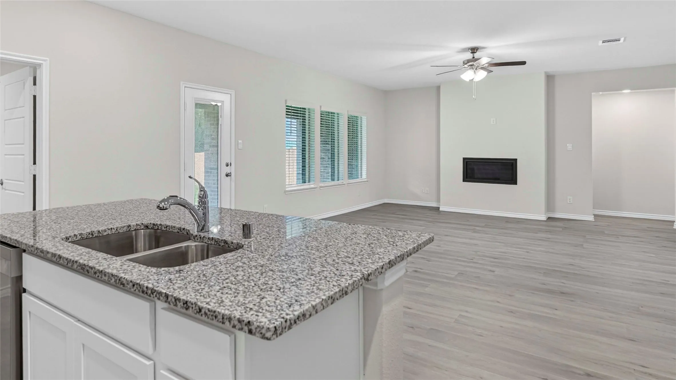 Kitchen island featuring a double basin stainless steel sink and granite countertops