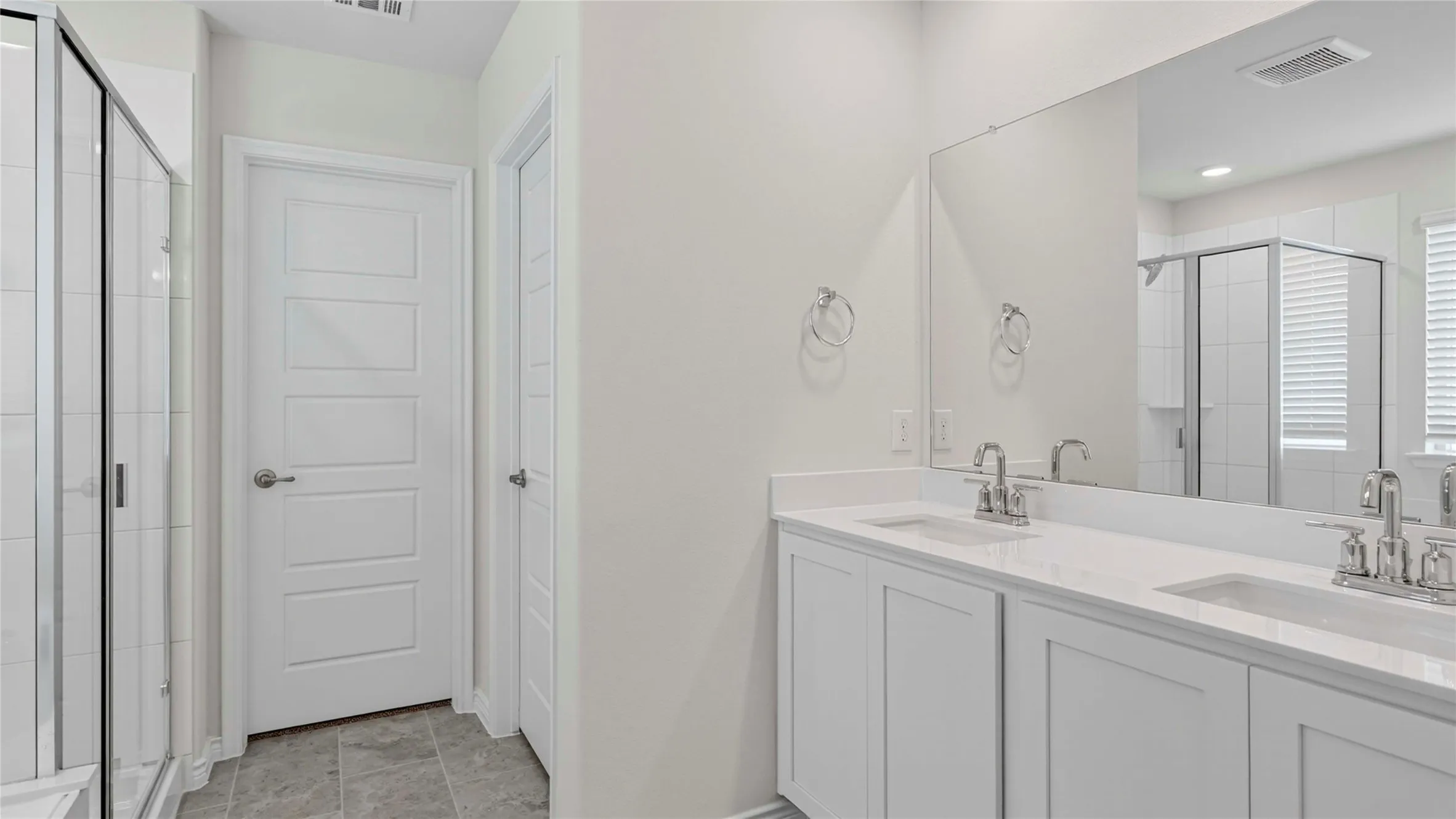 Double vanity with white cabinetry, integrated sinks, and chrome faucets