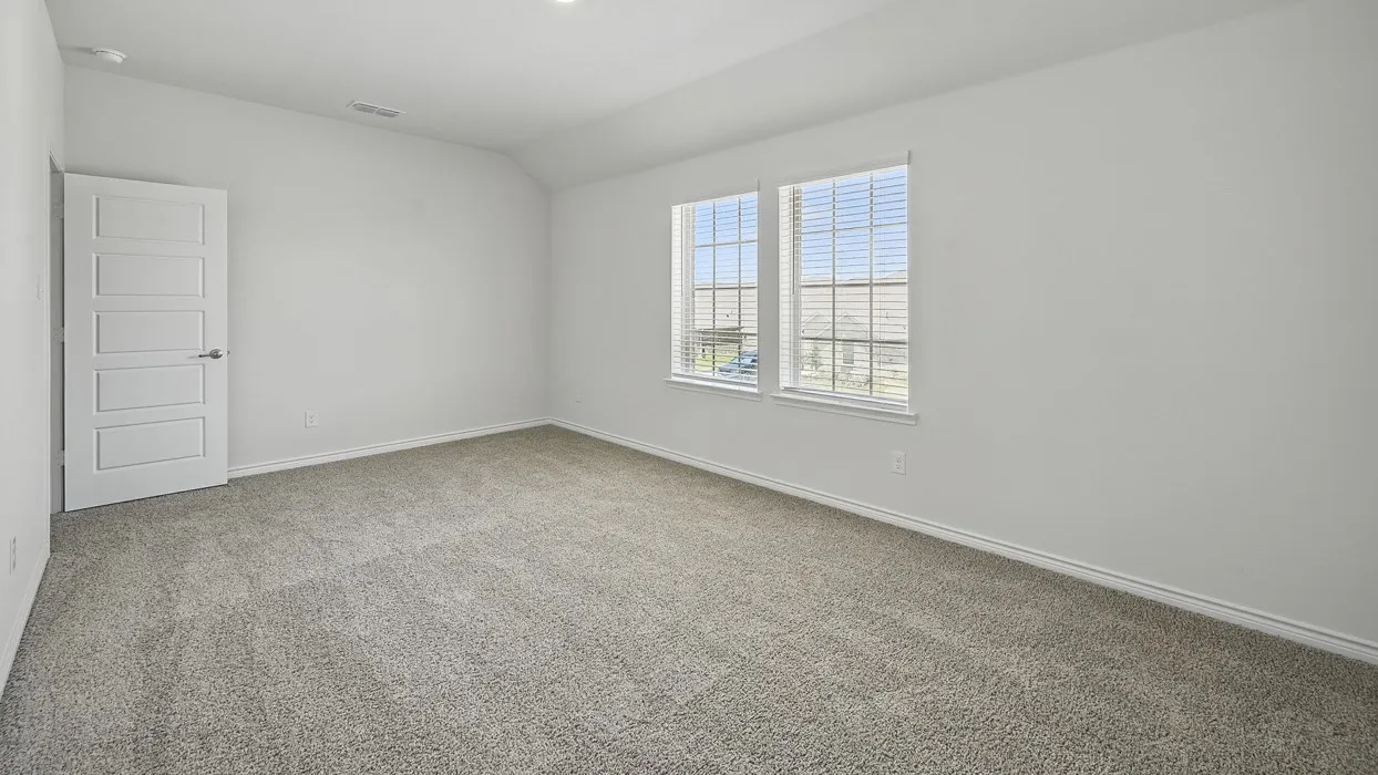 Spacious room featuring neutral carpeting, white walls, two windows with blinds, a modern paneled door, and recessed lighting