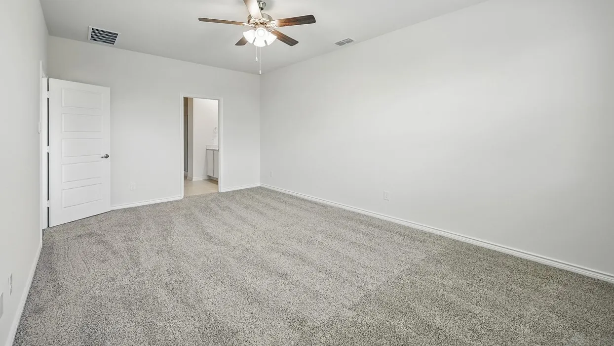 Spacious room featuring neutral carpeting, a modern ceiling fan with lighting, white walls, and a contemporary five-panel interior door