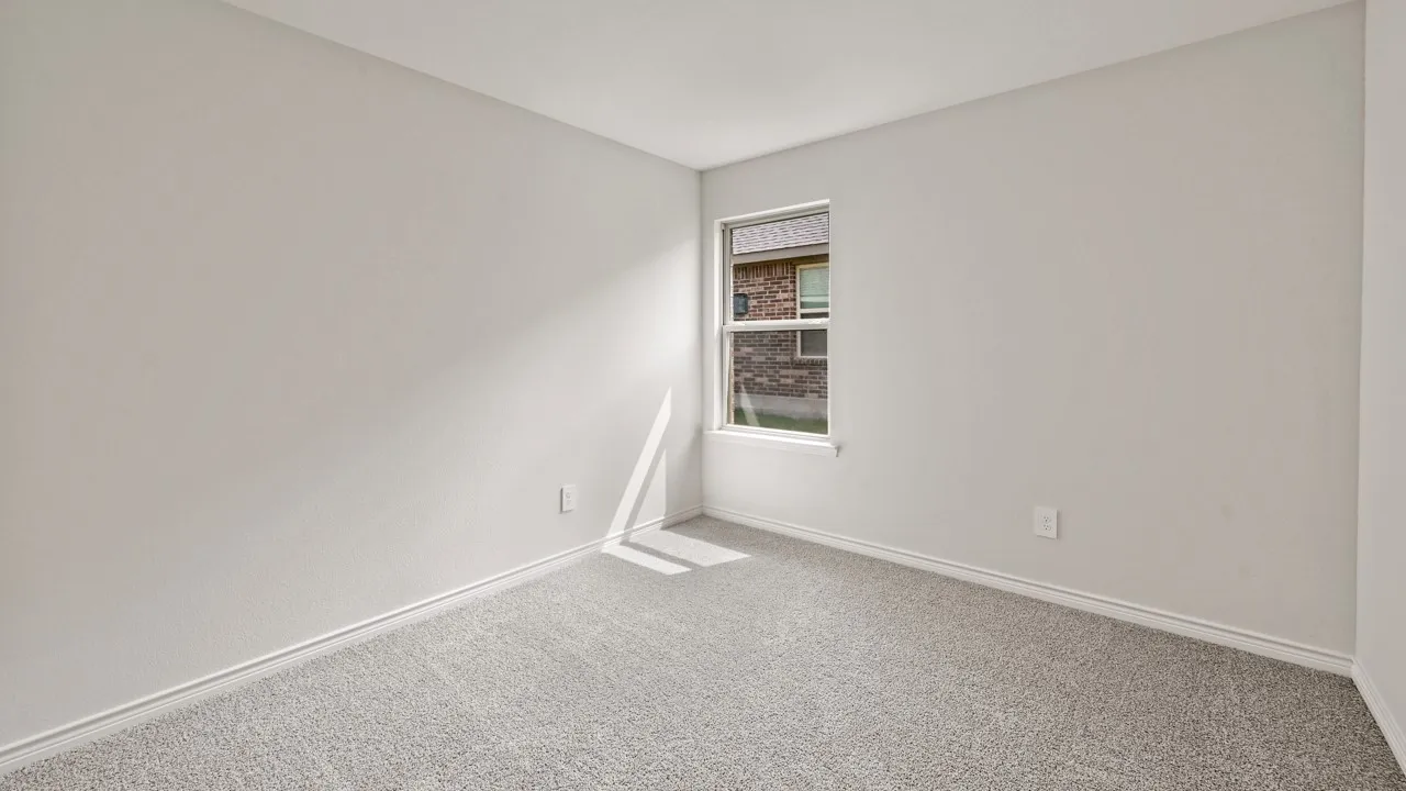 Interior room featuring light gray wall paint, gray carpet flooring, and a single window with white trim