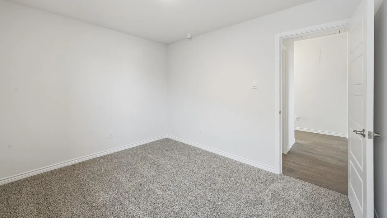 Neutral-toned carpet flooring and white baseboards