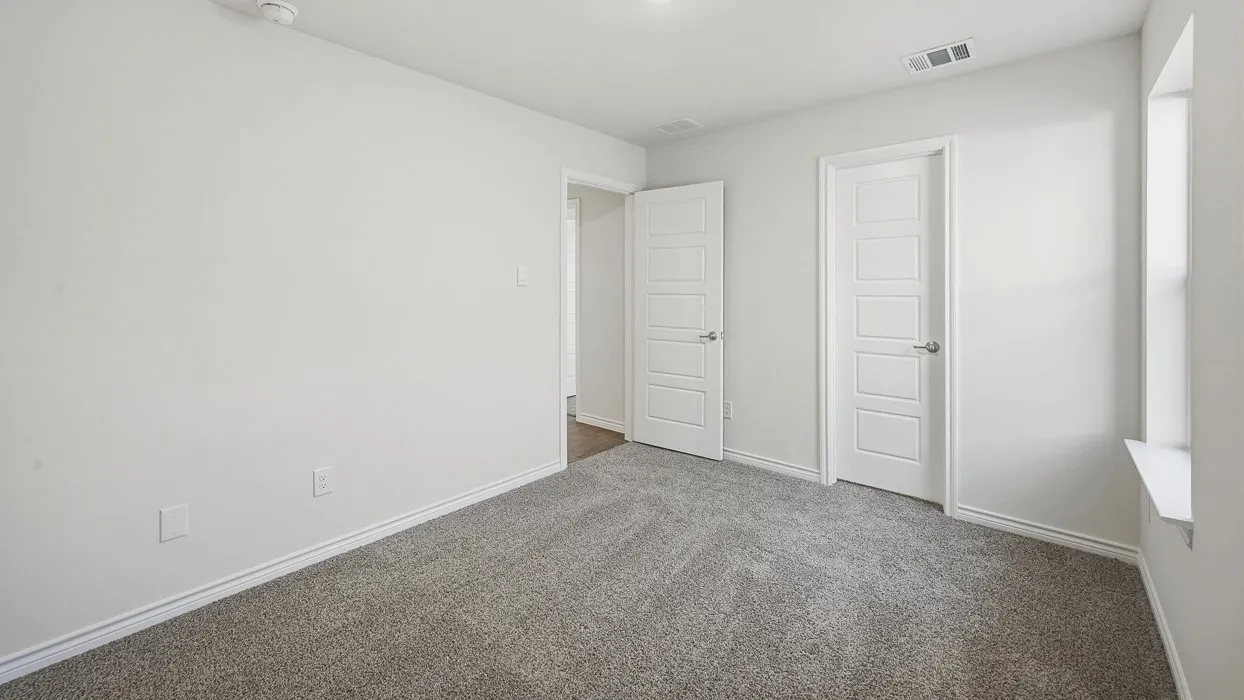 Carpeted interior room with white walls, white trim, and a window ledge