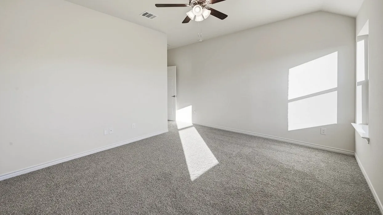 Spacious interior room featuring vaulted ceilings, light gray carpeting, and white walls