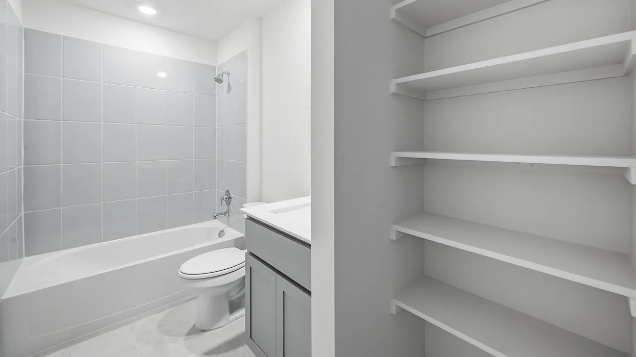 Full bathroom featuring a white tub, light gray wall tiling, a toilet, a vanity with a white countertop, and recessed lighting
