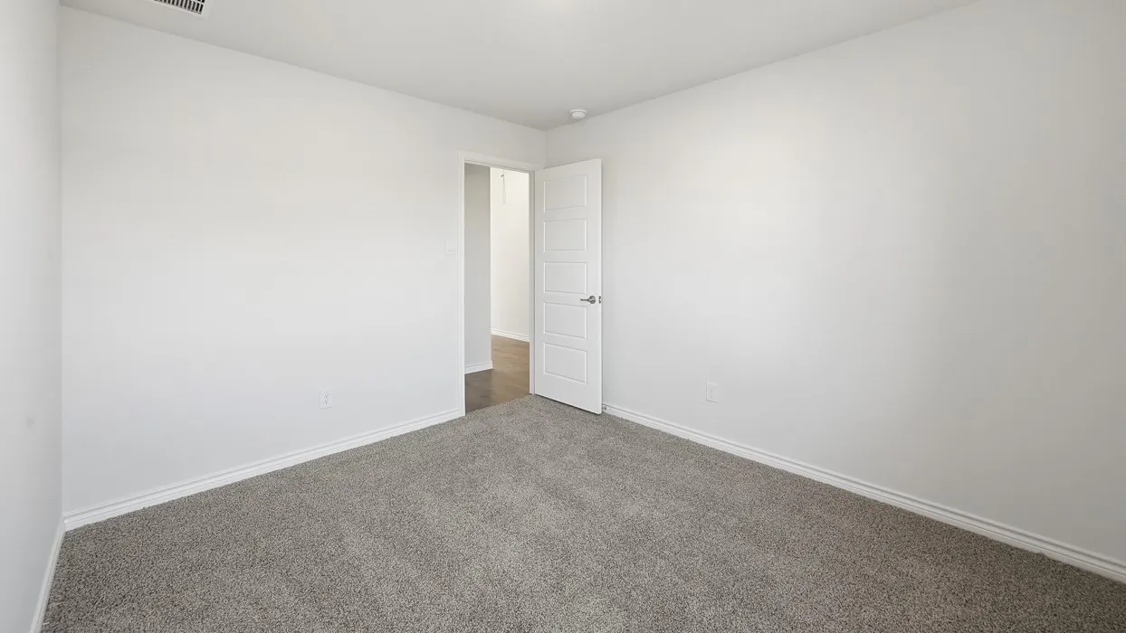 Spacious room featuring neutral carpeting, white walls, and white baseboards