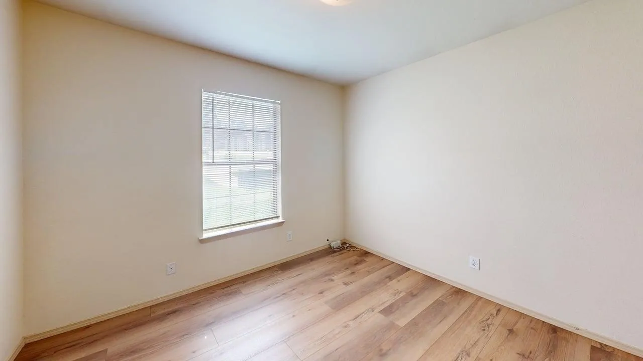 Room featuring wood-finish flooring, neutral-toned walls, and a recessed ceiling light