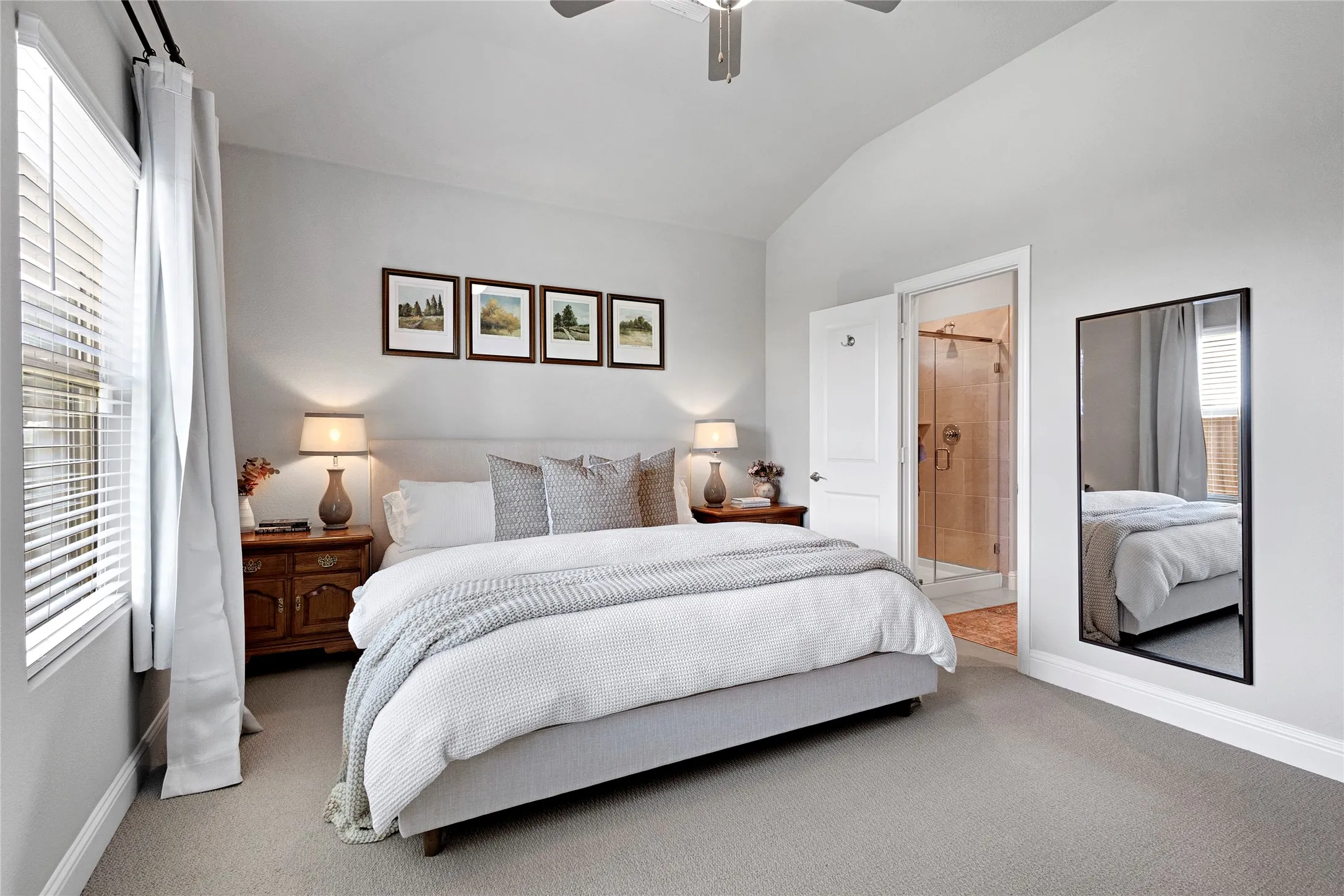 Primary bedroom with ensuite bath, ceiling fan, and blinds.