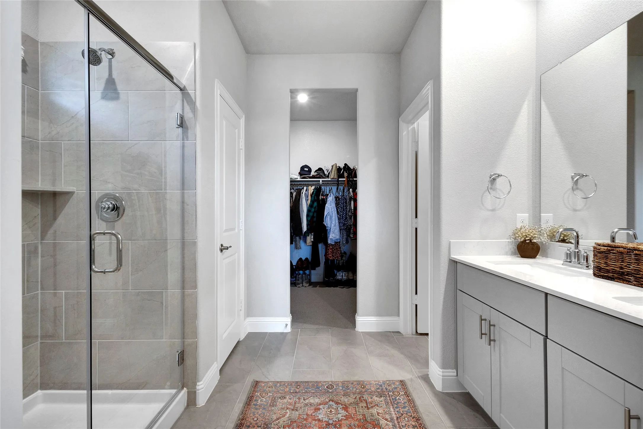 Ensuite bath with dual sinks, quartz countertops and walk in closet.