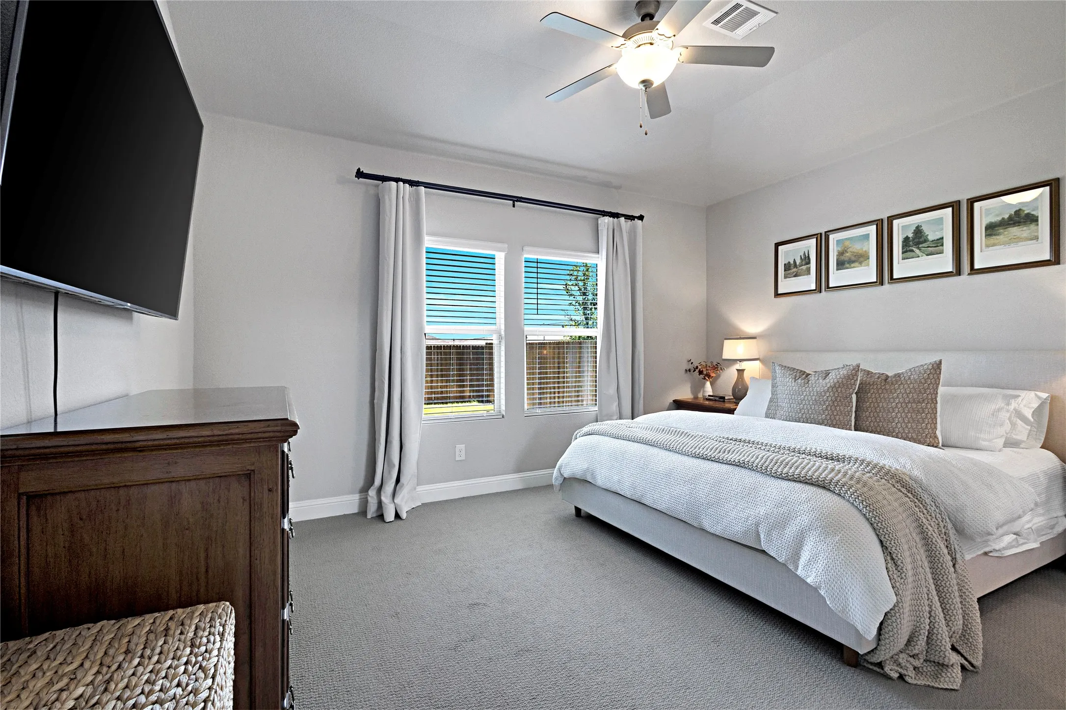 Primary bedroom with ceiling fan and upgraded carpet.