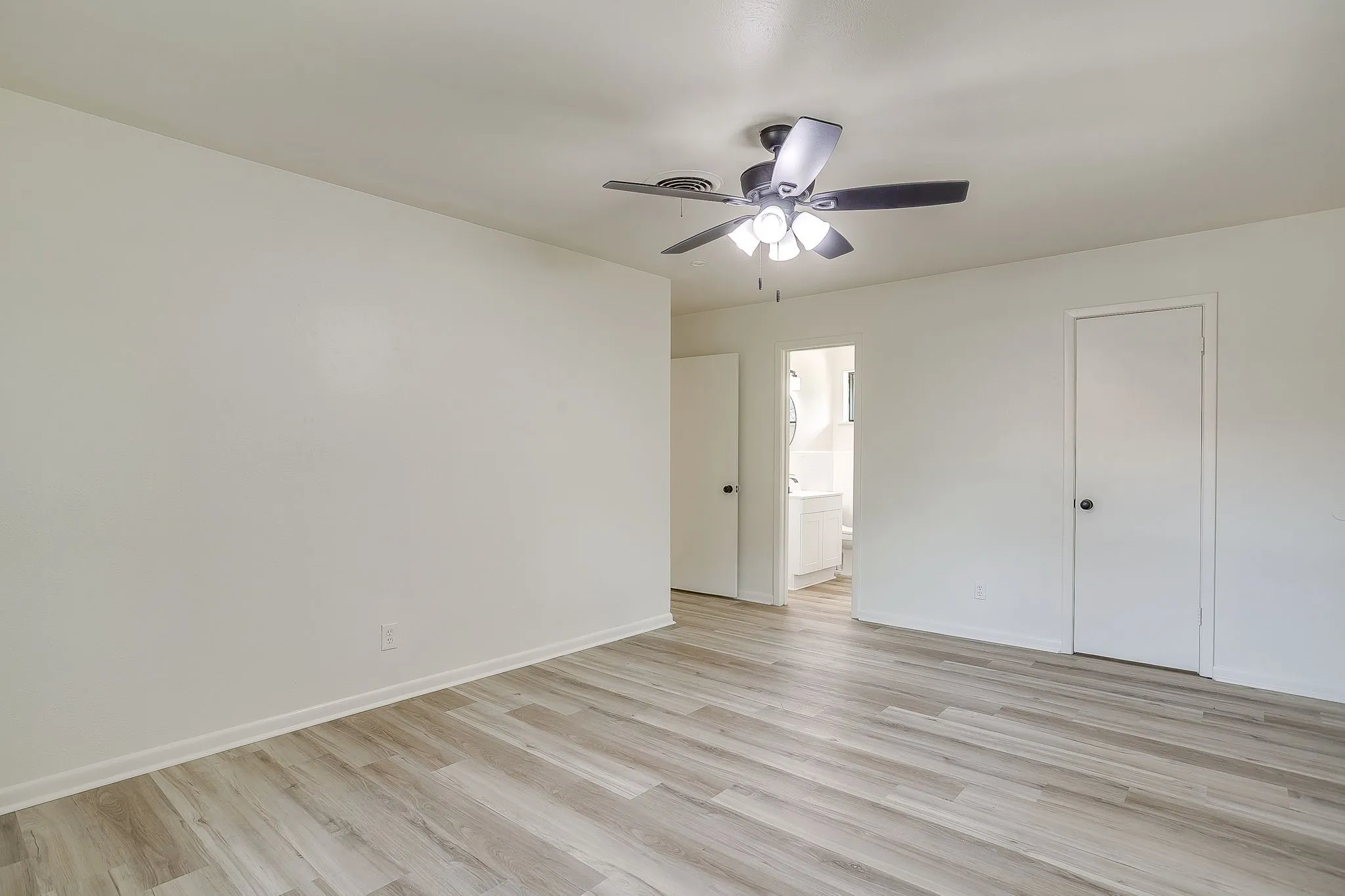 Bright room featuring wood-finish flooring and white baseboards