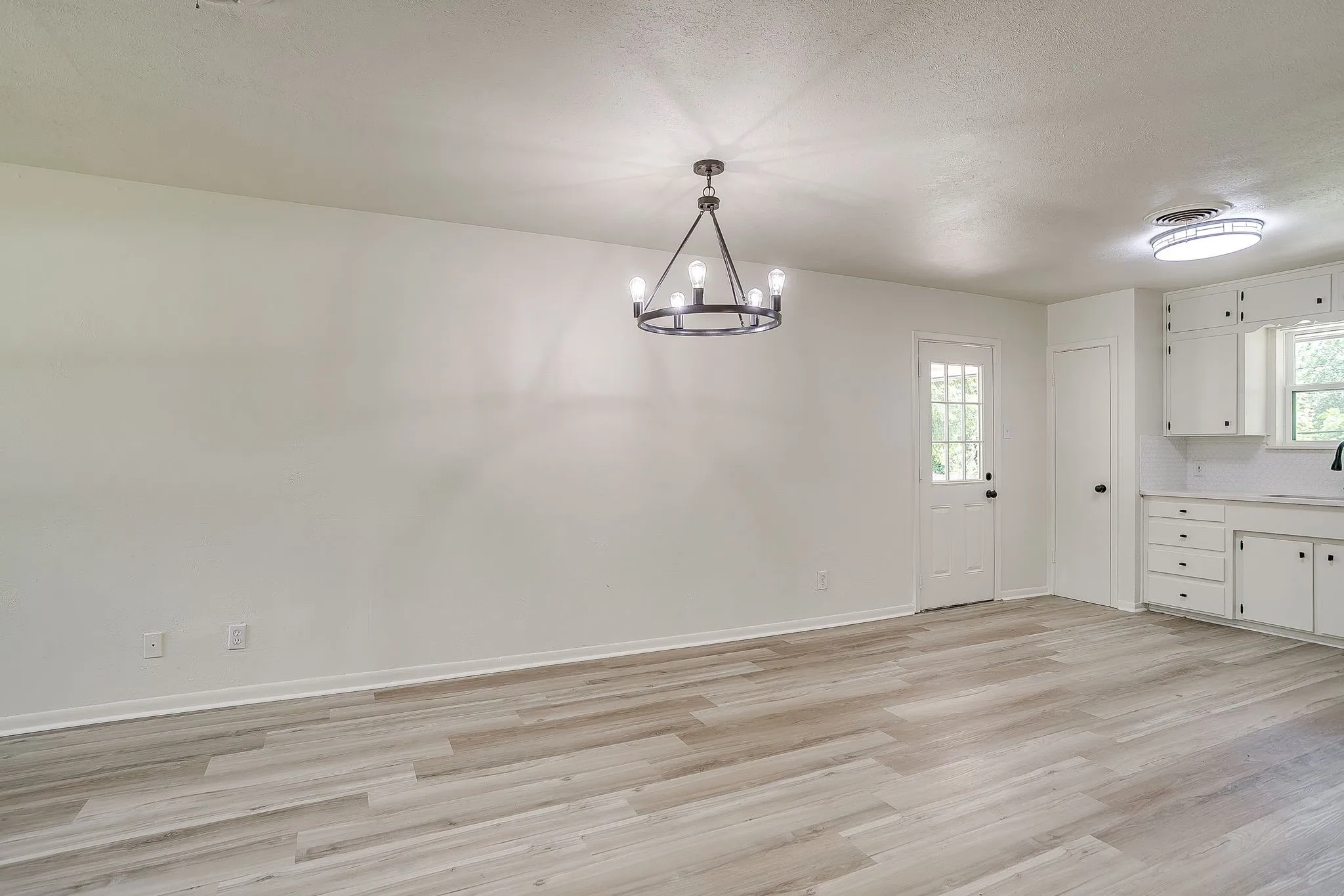 Open-concept living space with light wood-finish flooring