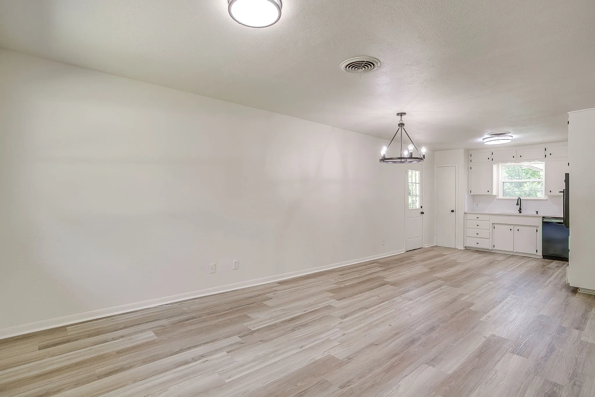 Open-concept living space with light wood-finish flooring
