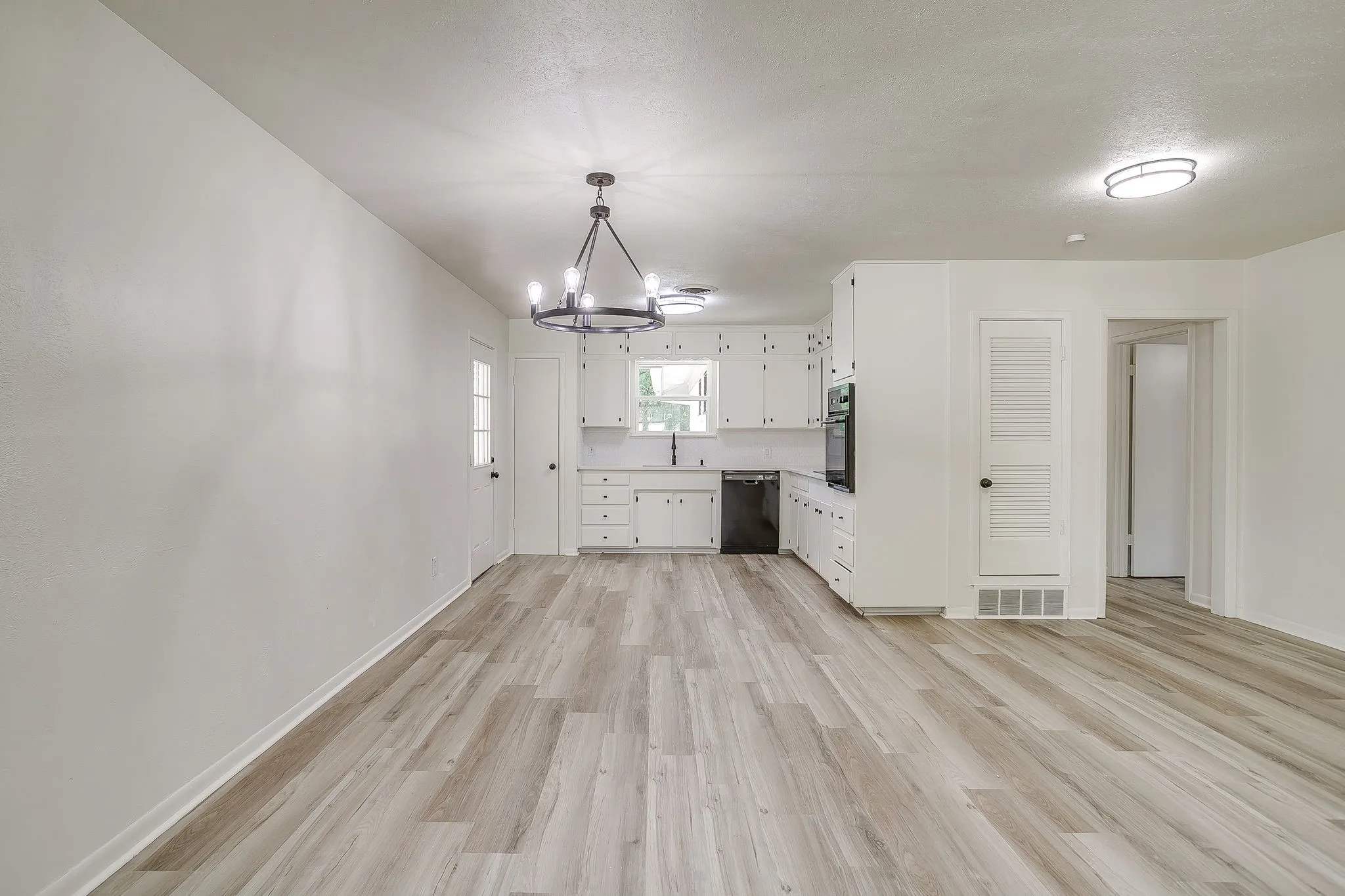 Open-concept living space with light wood-finish flooring