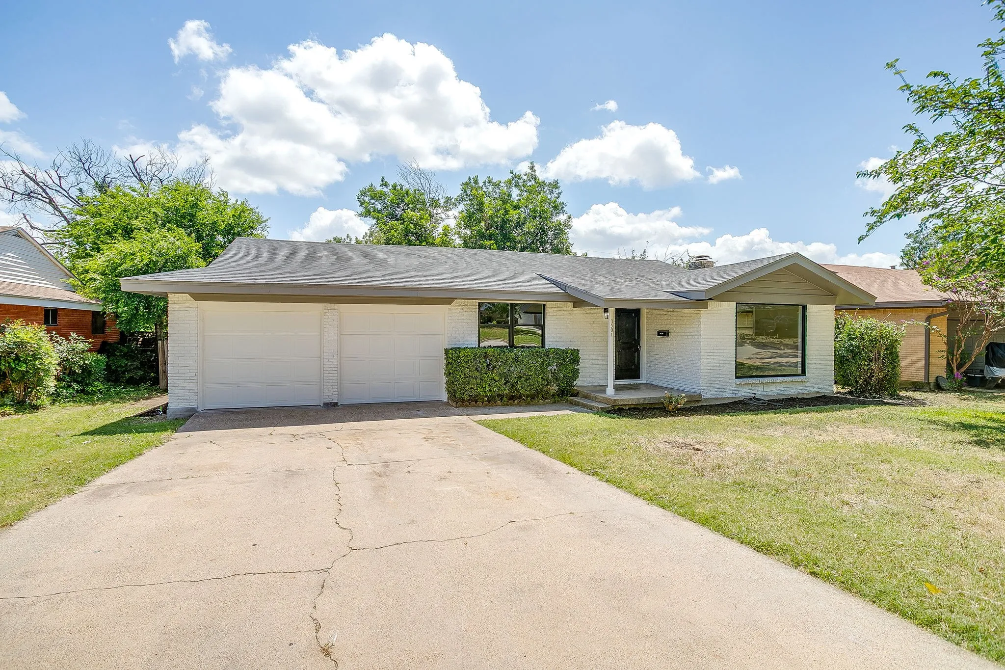 Single-story residence featuring a two-car garage, concrete driveway, and a covered entry