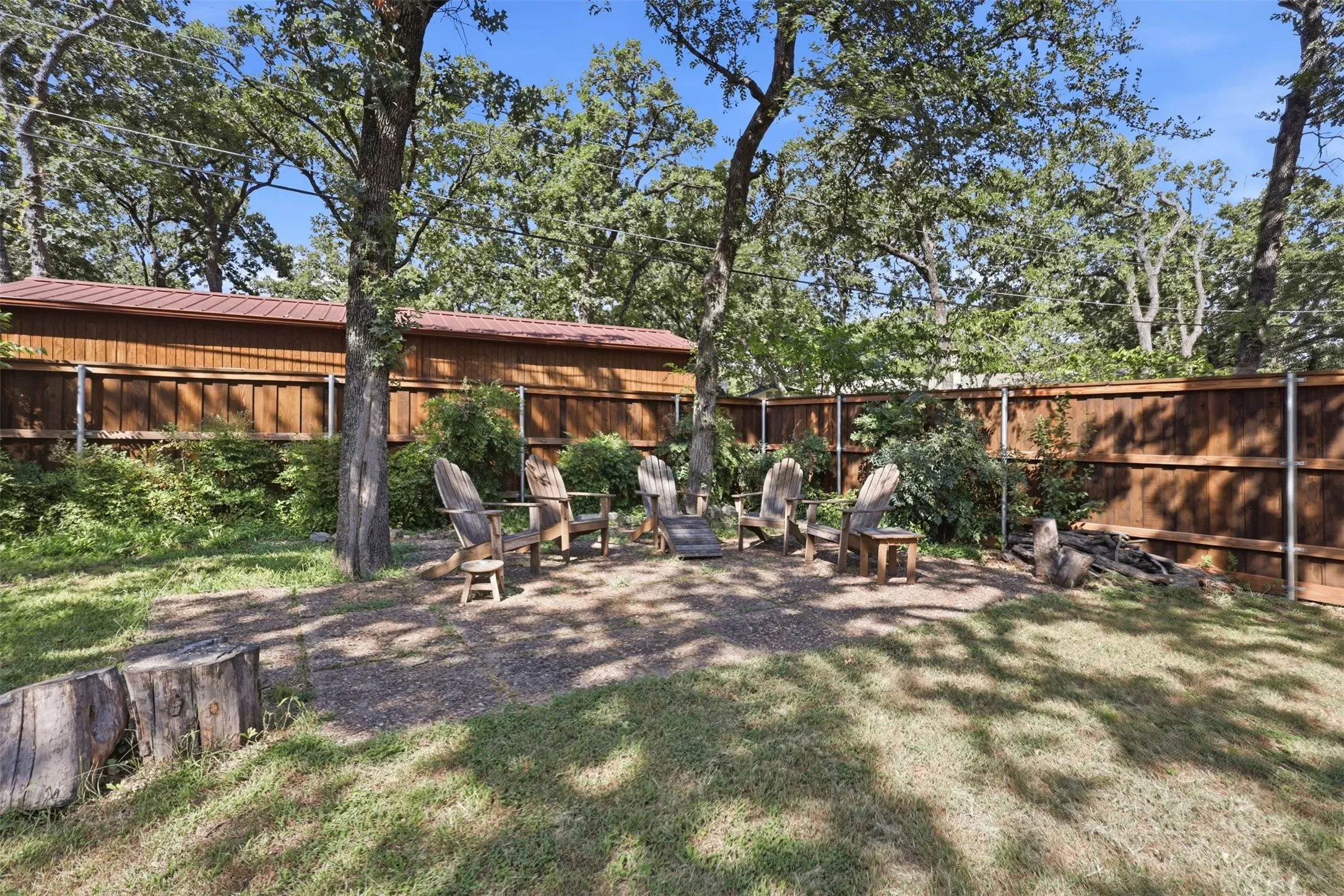 Shaded backyard gathering area offering a peaceful setting for relaxing and entertaining.
