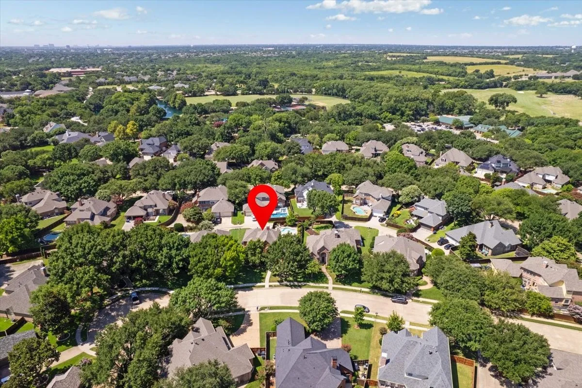 Aerial perspective showcasing a residential neighborhood with numerous mature trees and green spaces