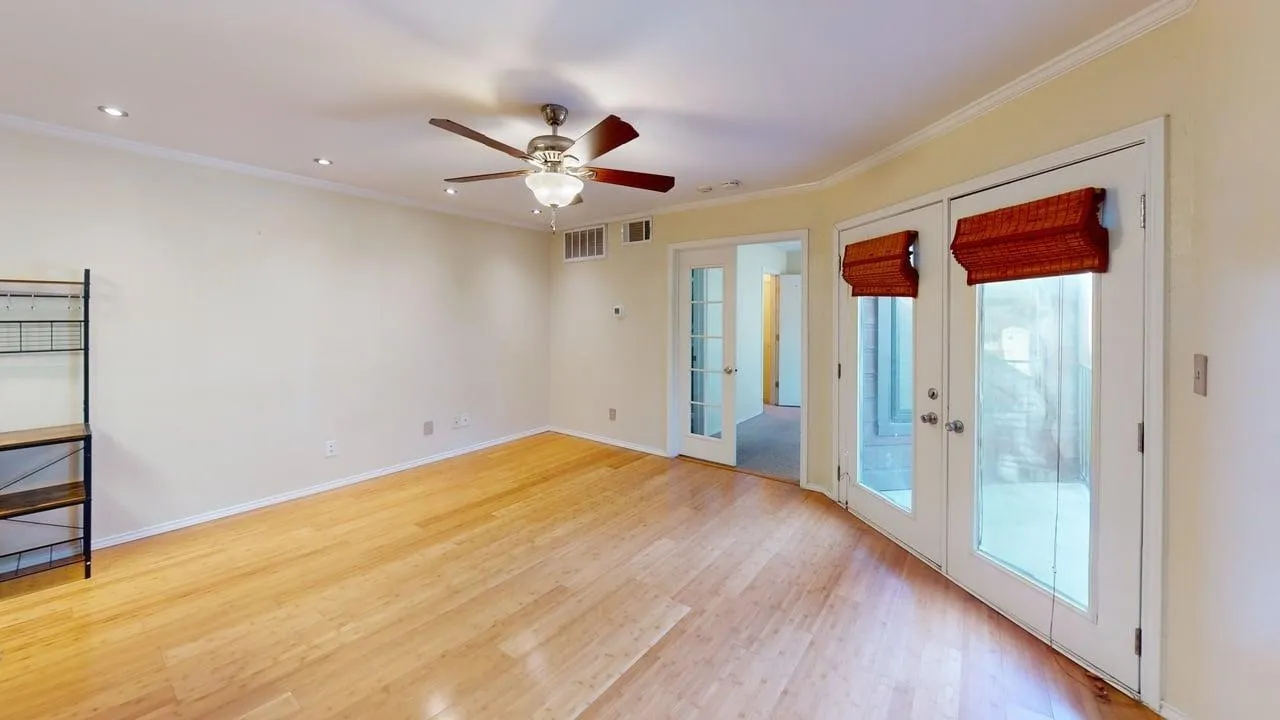 Spacious interior room featuring wood-finish flooring, recessed lighting, and a ceiling fan with light fixture