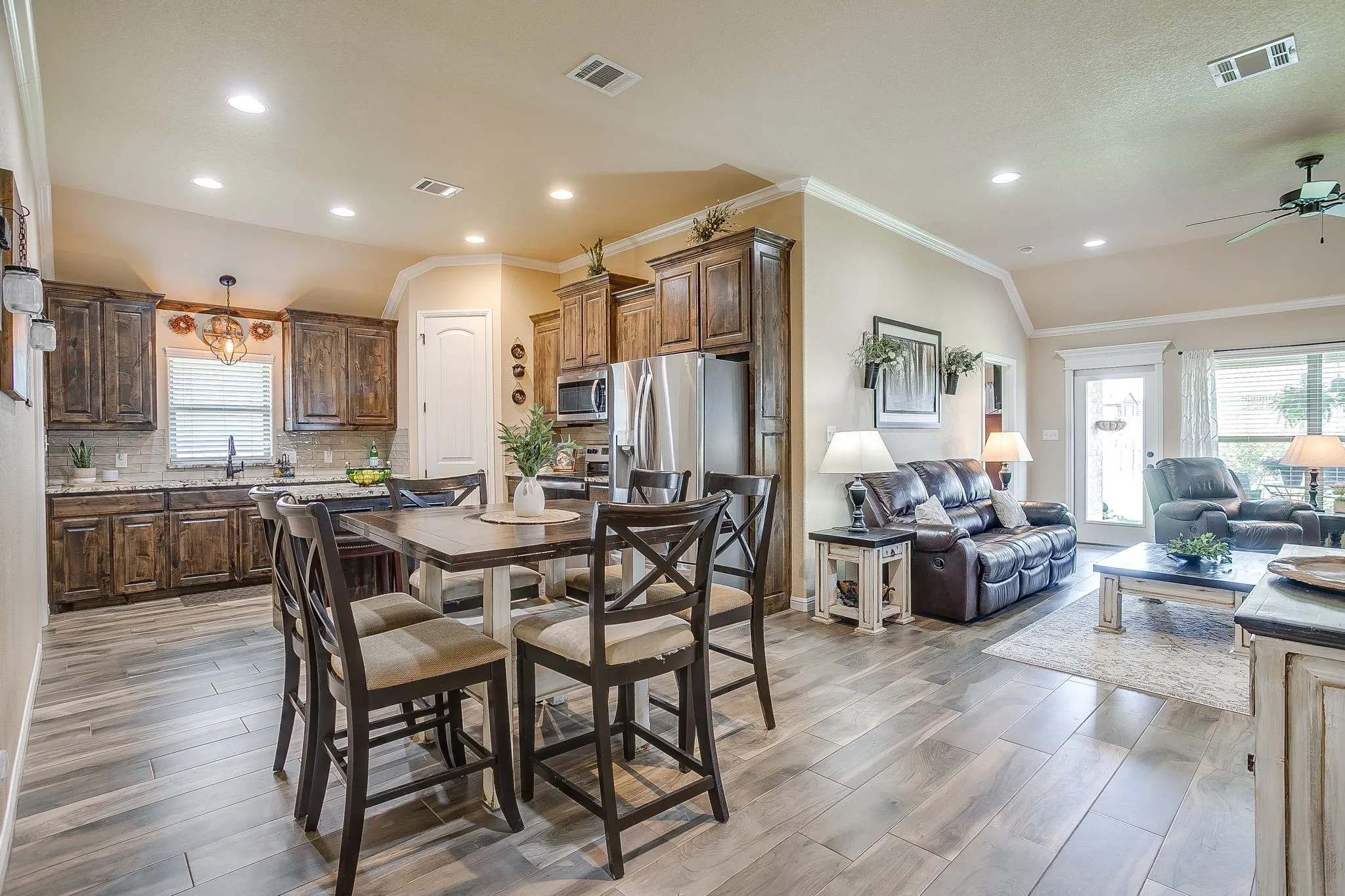 Living area featuring a stone fireplace with a wood mantle, vaulted ceilings, recessed lighting, and wood-finish flooring
