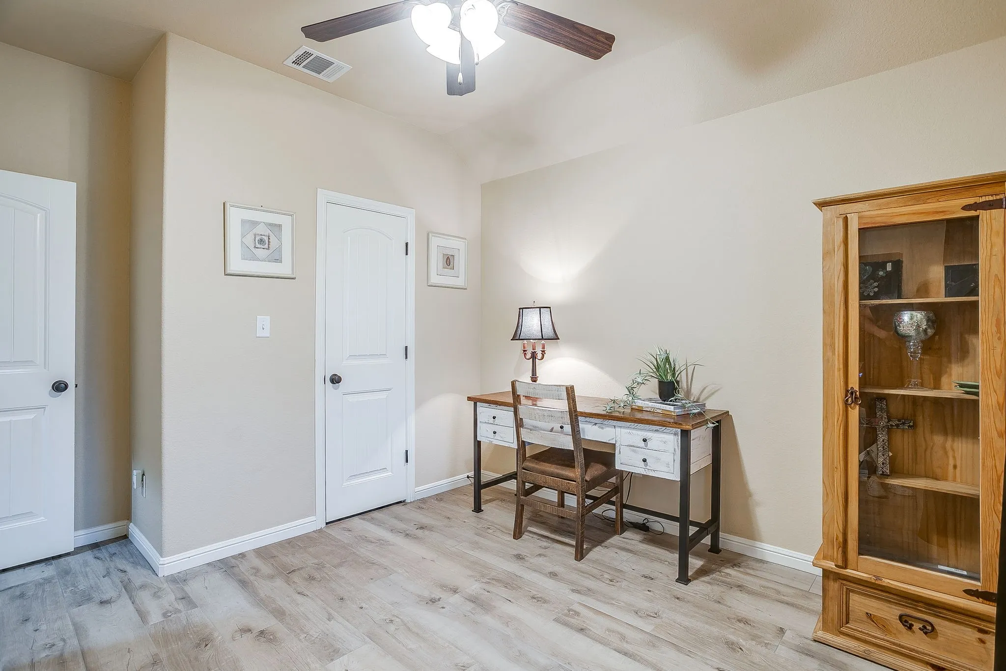 Spacious room featuring light wood-finish flooring, neutral wall paint, and white trim