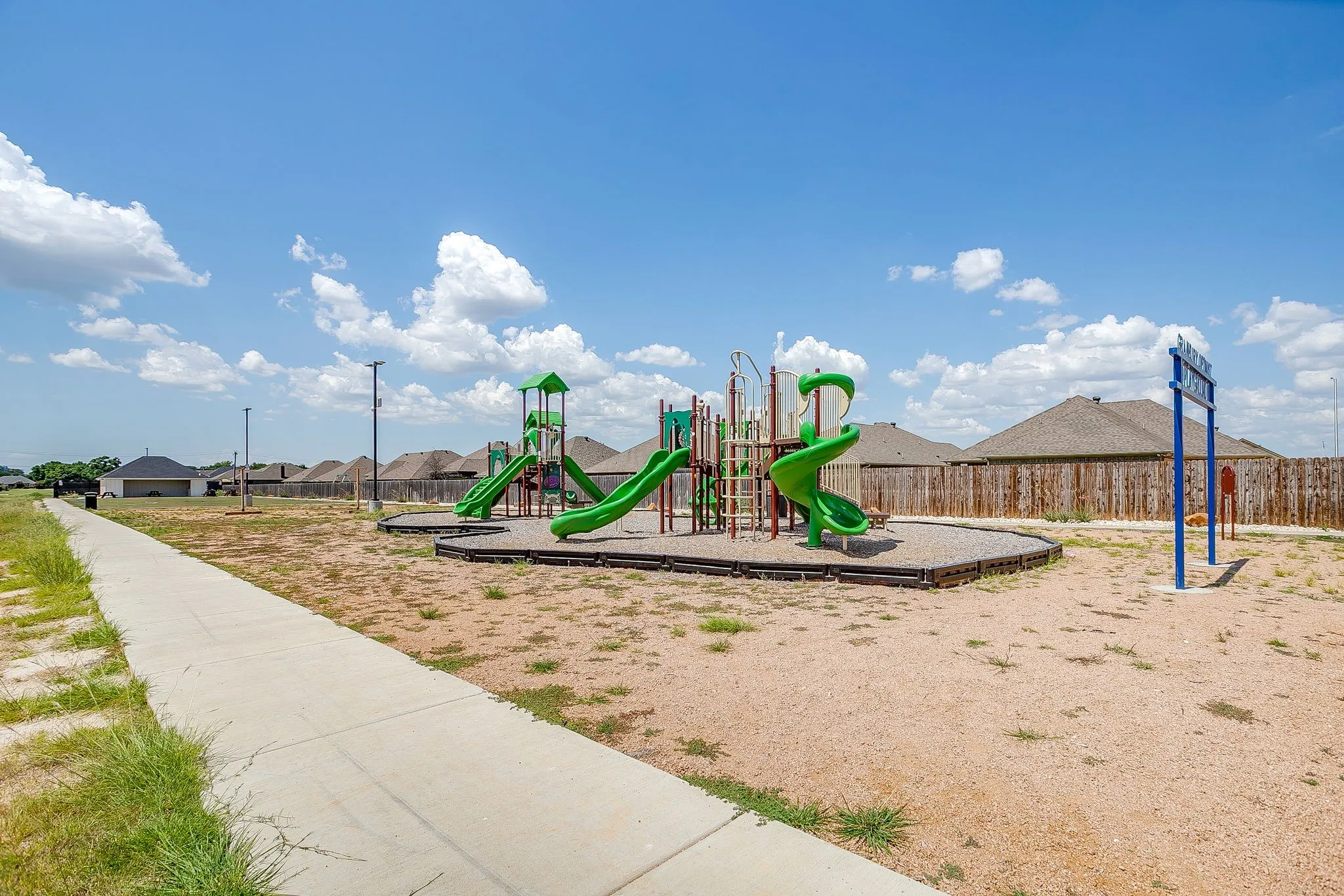 Community playground featuring multiple slides, climbing structures, and ground-level play elements