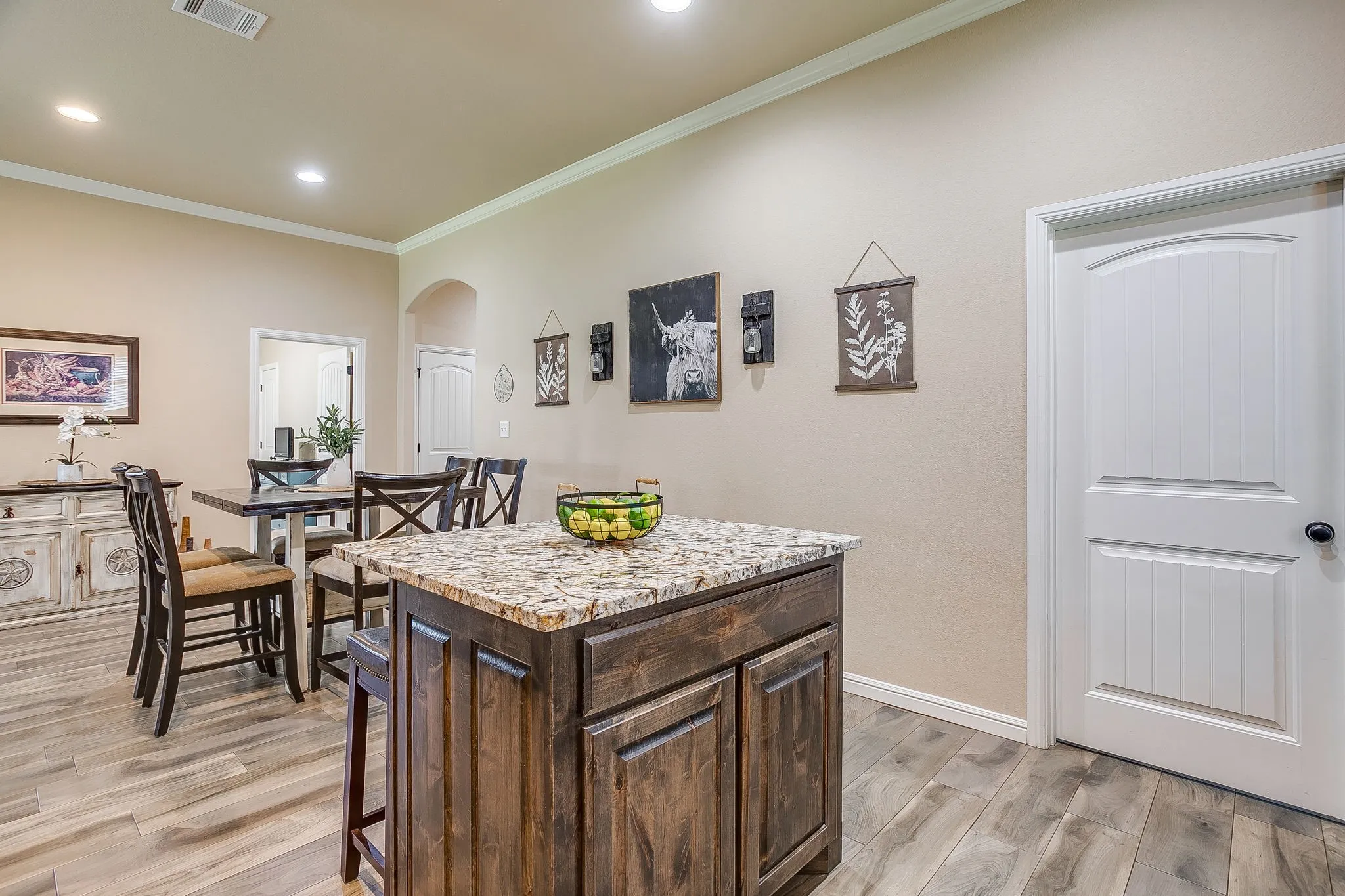 Open-concept living space featuring wood-finish flooring, recessed lighting, and crown molding