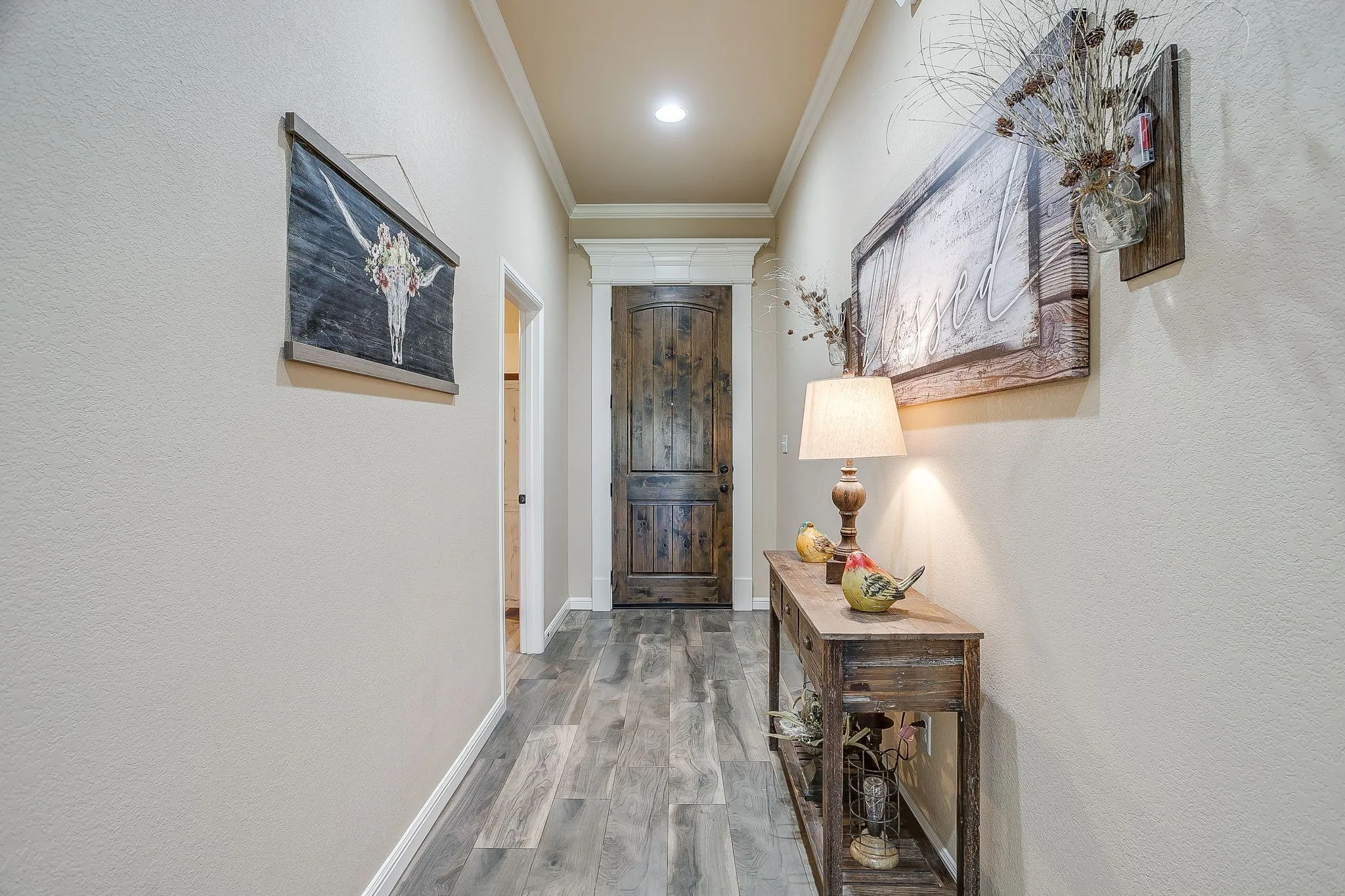 Kitchen featuring wood-finish cabinetry, stainless steel appliances, a center island with a stone-finish countertop, and wood-look flooring