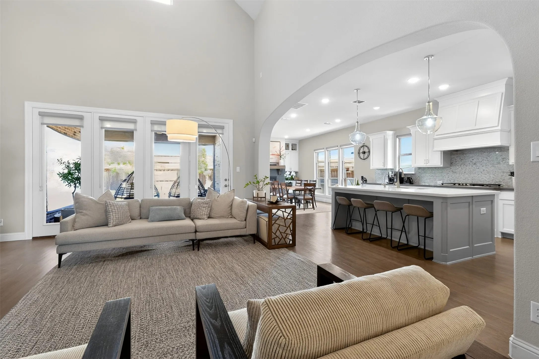 Expansive living space featuring high ceilings and wood-finish flooring