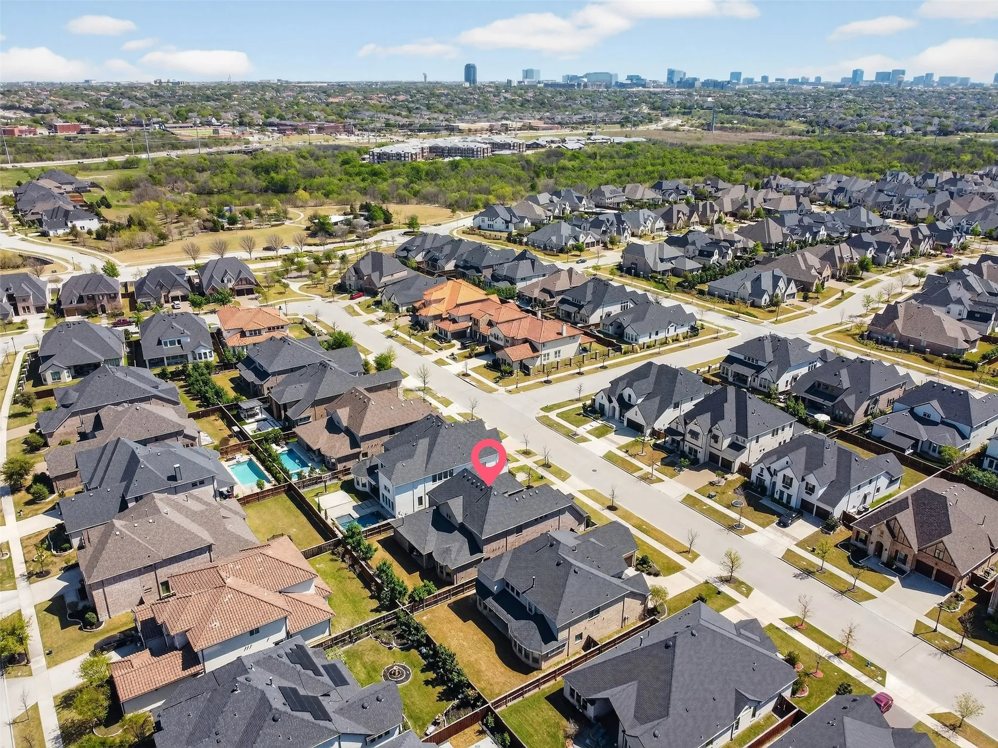 Aerial perspective showcasing a residential neighborhood with detached homes, mature landscaping, and an organized street grid