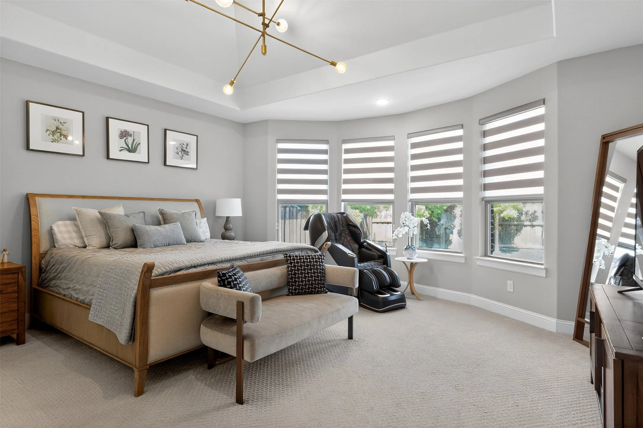 Carpeted room featuring a tray ceiling with a modern linear light fixture